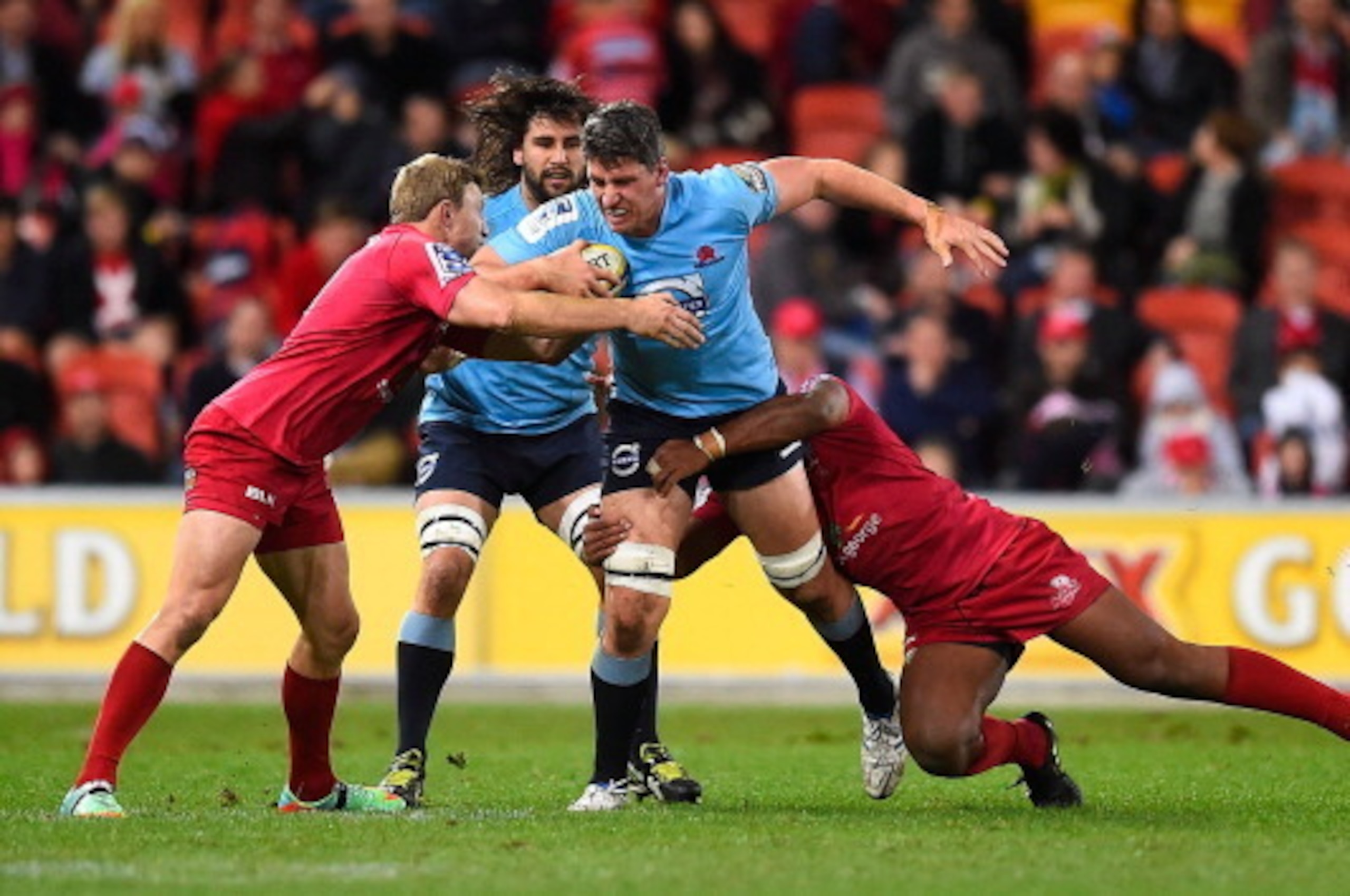 BRISBANE, AUSTRALIA - JULY 12:  Mitchell Chapman of the Waratahs is wrapped up by the Reds defence during the round 19 Super Rugby match between the Reds and the Waratahs at Suncorp Stadium on July 12, 2014 in Brisbane, Australia.  (Photo by Ian Hitchcock