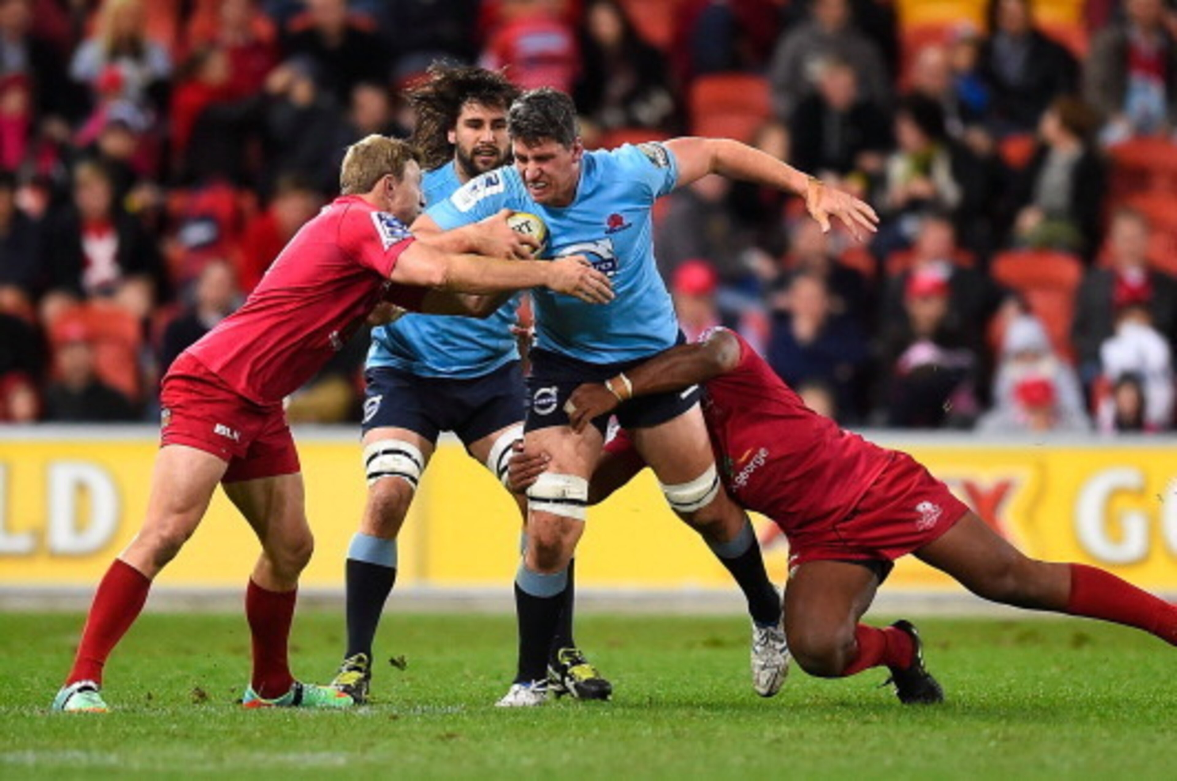 BRISBANE, AUSTRALIA - JULY 12:  Mitchell Chapman of the Waratahs is wrapped up by the Reds defence during the round 19 Super Rugby match between the Reds and the Waratahs at Suncorp Stadium on July 12, 2014 in Brisbane, Australia.  (Photo by Ian Hitchcock