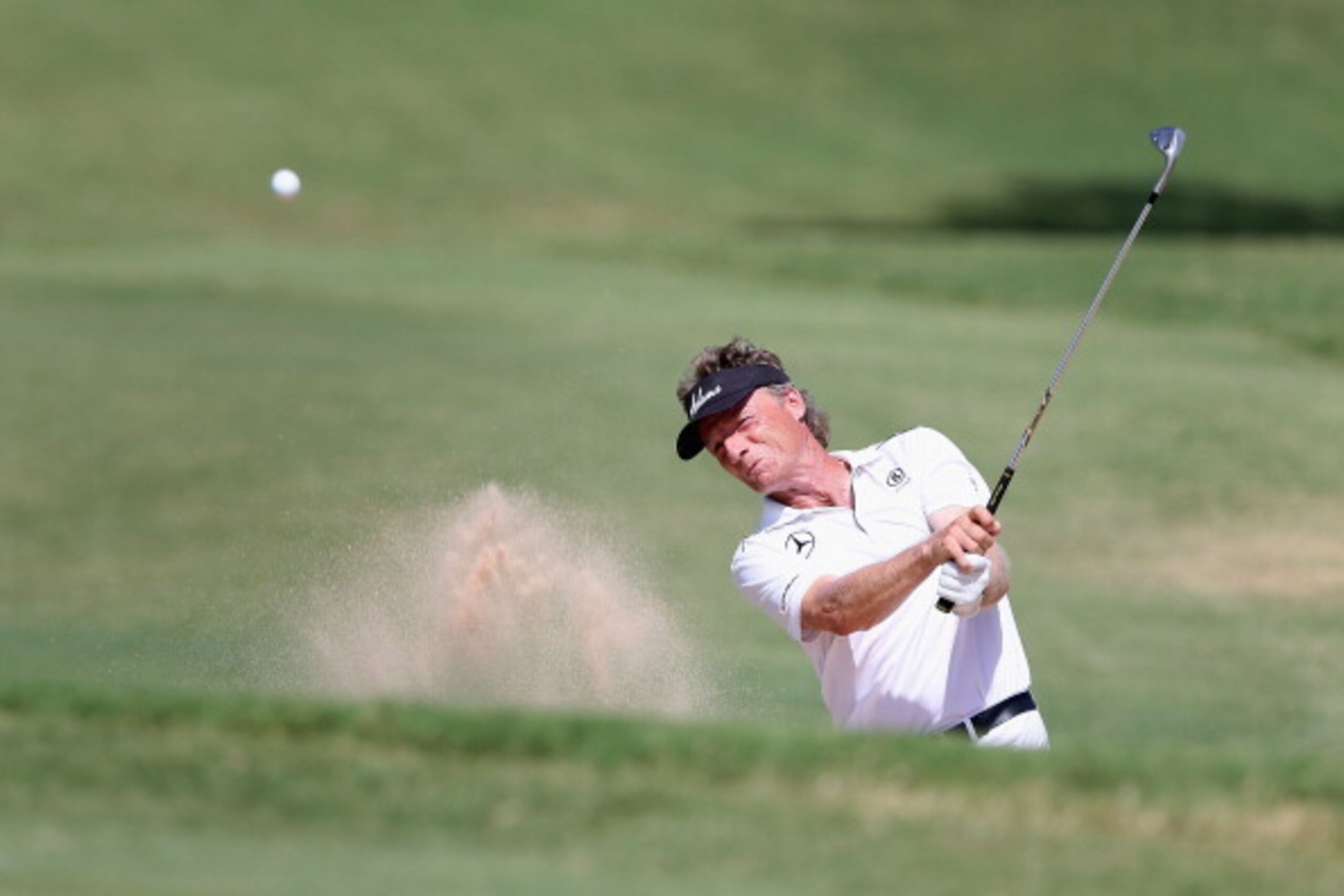 EDMOND, OK - JULY 13:  Bernhard Langer of Germany chips from the bunker over the 16th green during the final round of the 2014 U.S. Senior Open Championship at Oak Tree National on July 13, 2014 in Edmond, Oklahoma.  (Photo by Christian Petersen/Getty Ima