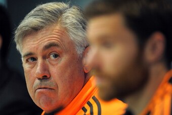 MADRID, SPAIN - APRIL 22:  Head coach Carlo Ancelotti (L) of Real Madrid FC listens to a question beside Real player Xabi Alonso during their press conference at Valdebebas training ground ahead of the UEFA Champions League semi-final first leg match agai