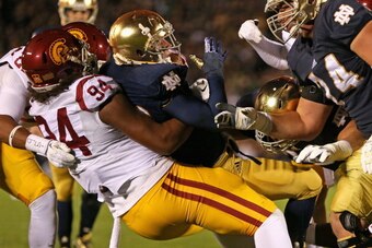 SOUTH BEND, IN - OCTOBER 19:  Leonard Williams #94 of the University of Southern California Trojans drops Cam McDaniel #33 of the Notre Dame Fighting Irish at Notre Dame Stadium on October 19, 2013 in South Bend, Indiana.  (Photo by Jonathan Daniel/Getty 
