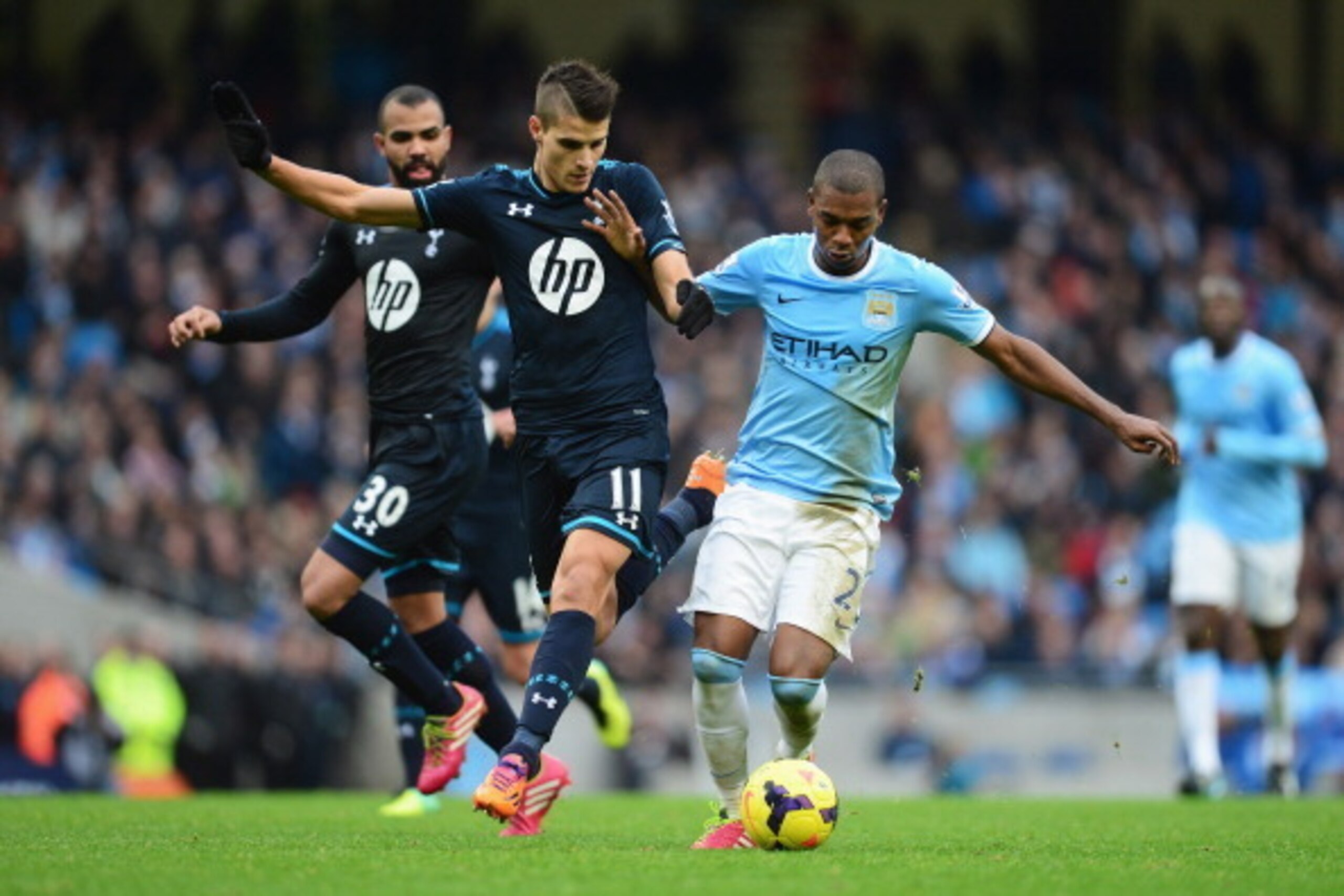 MANCHESTER, ENGLAND - NOVEMBER 24:  Erik Lamela of Tottenham Hotspur challenges Fernandinho of Manchester City during the Barclays Premier League match between Manchester City and Tottenham Hotspur at Etihad Stadium on November 24, 2013 in Manchester, Eng