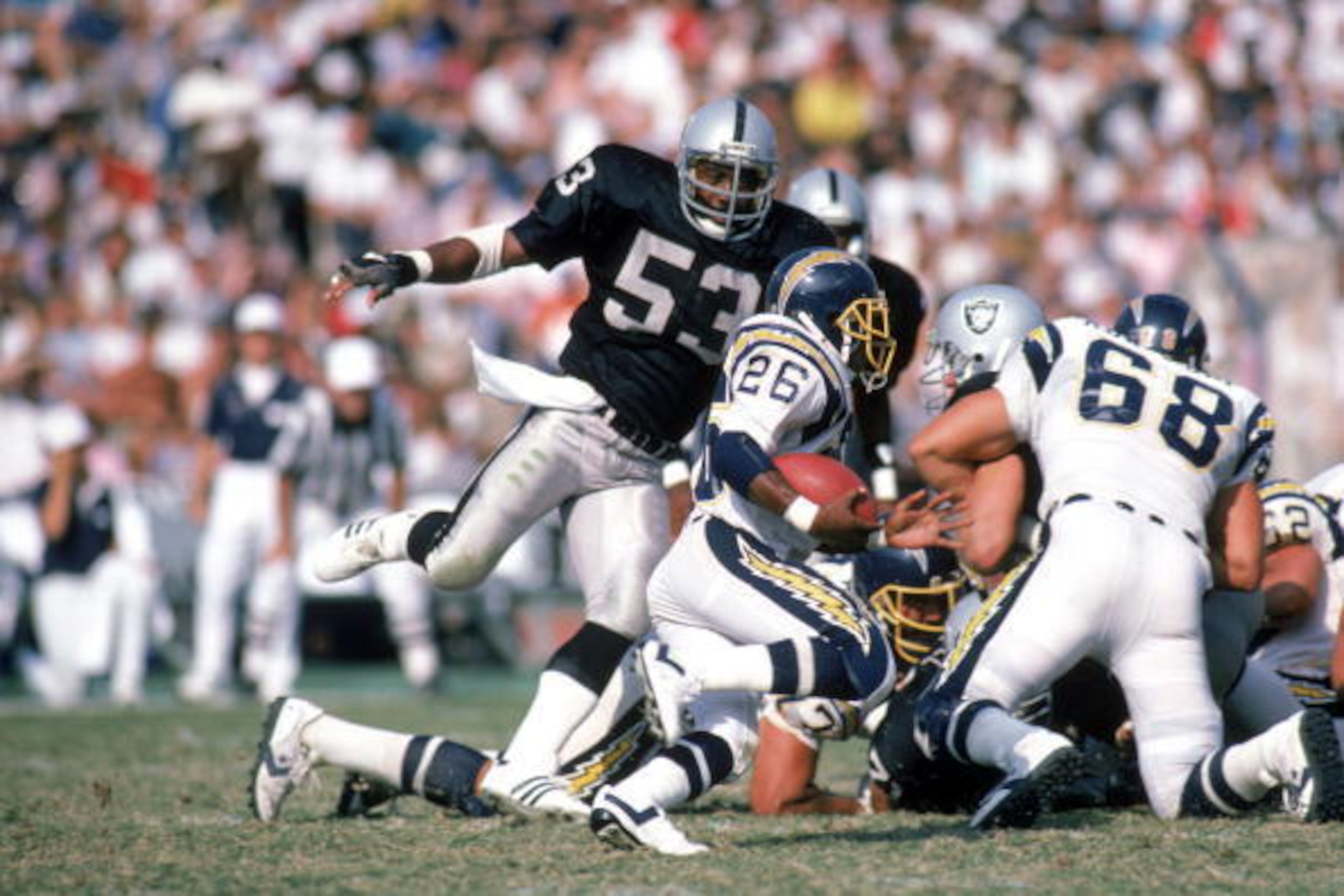 LOS ANGELES - SEPTEMBER 28:  Running back Lionel James #26 of the San Diego Chargers rushes for yards as linebacker Rod Martin #53 of the Los Angeles Raiders applies pressure during a game at the Los Angeles Memorial Coliseum on September 28, 1986 in Los 