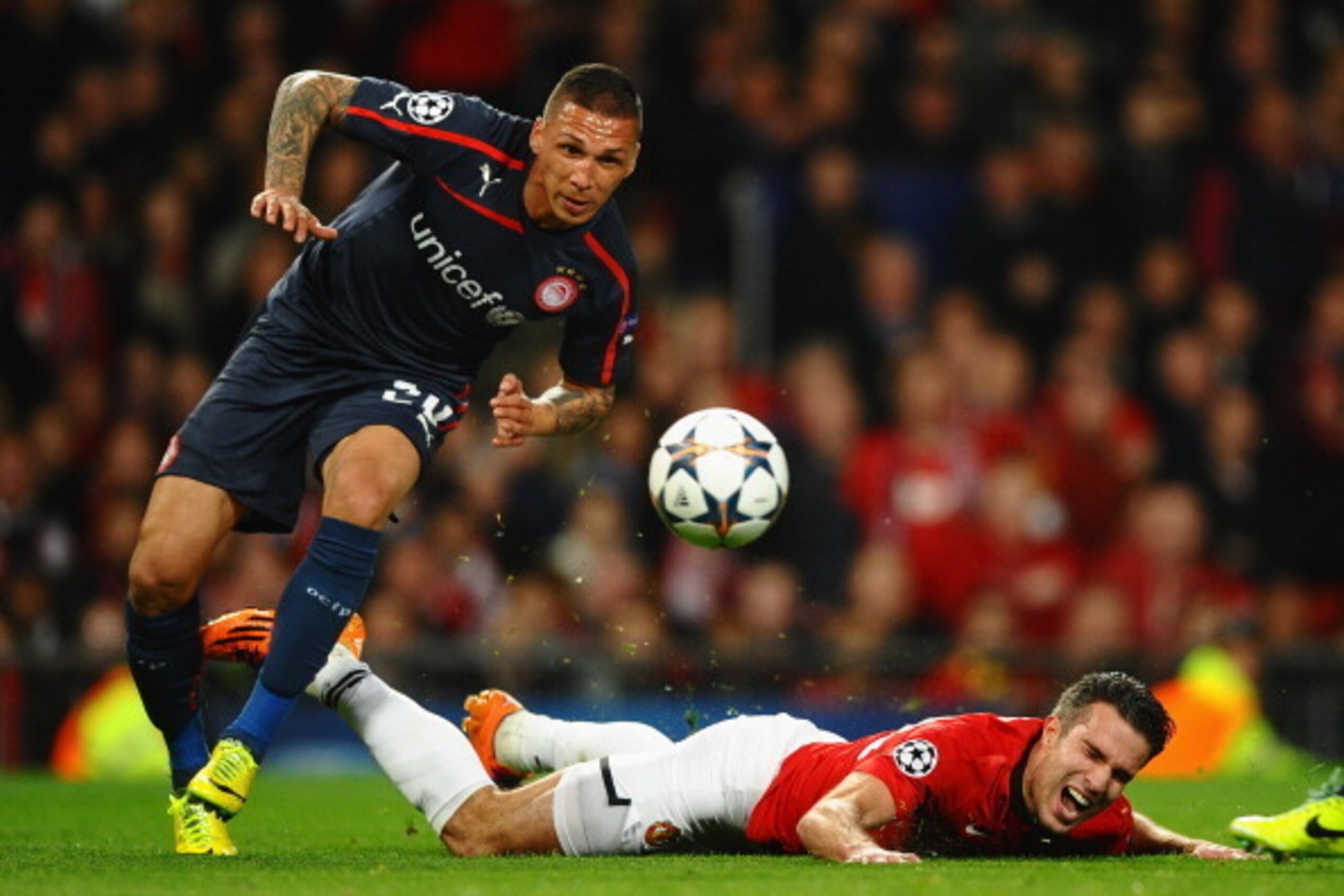 MANCHESTER, ENGLAND - MARCH 19:  Robin van Persie of Manchester United is fouled in the penalty box by Jose Holebas of Olympiacos during the UEFA Champions League Round of 16 second round match between Manchester United and Olympiacos FC at Old Trafford o