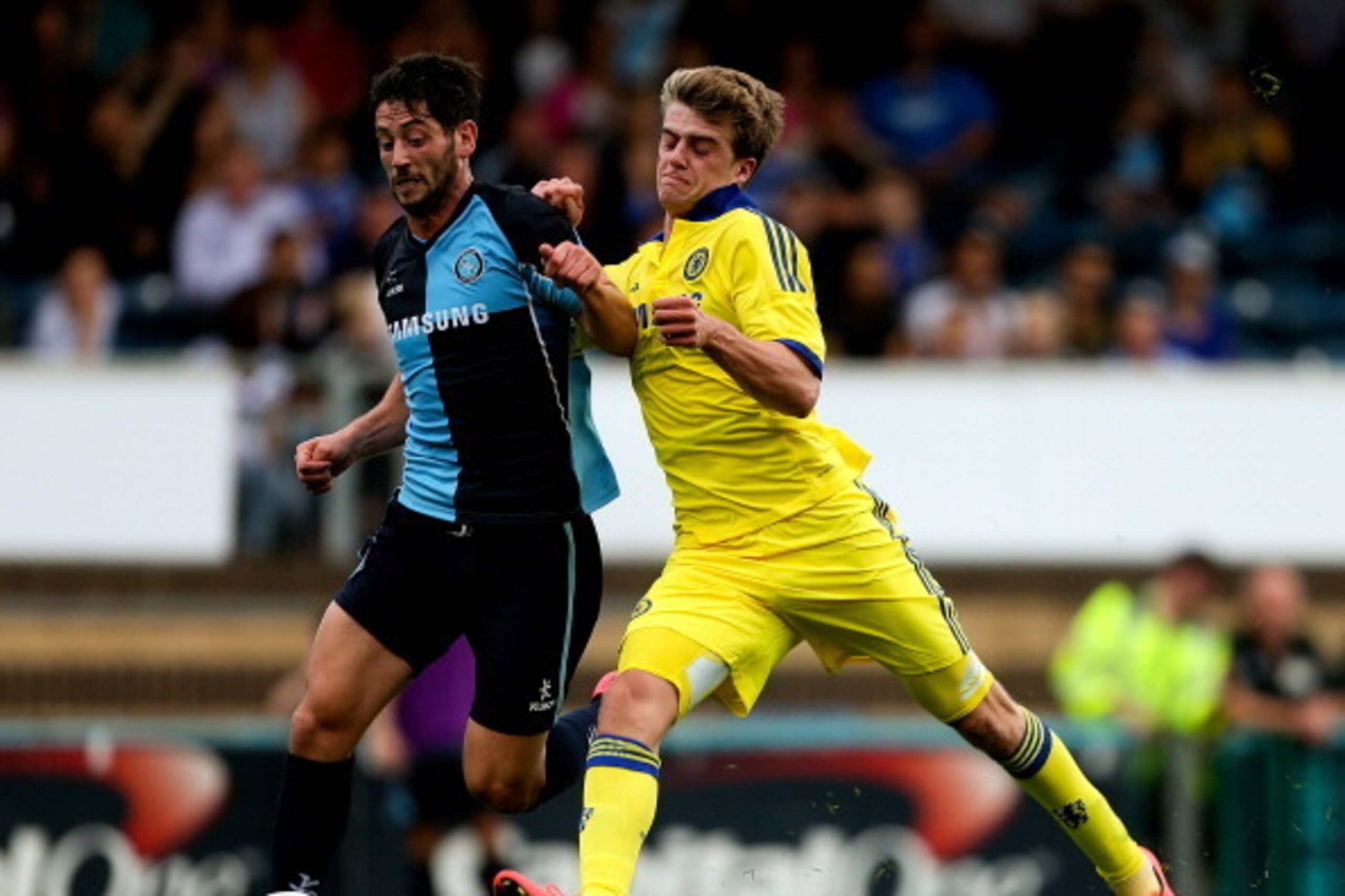 HIGH WYCOMBE, ENGLAND - JULY 16: Marco van Ginkel of Chelsea battles with Aaron Pierre of Wycombe duing the pre season friendly match between Wycombe Wanderers and Chelsea at Adams Park on July 16, 2014 in High Wycombe, England.  (Photo by Ben Hoskins/Get