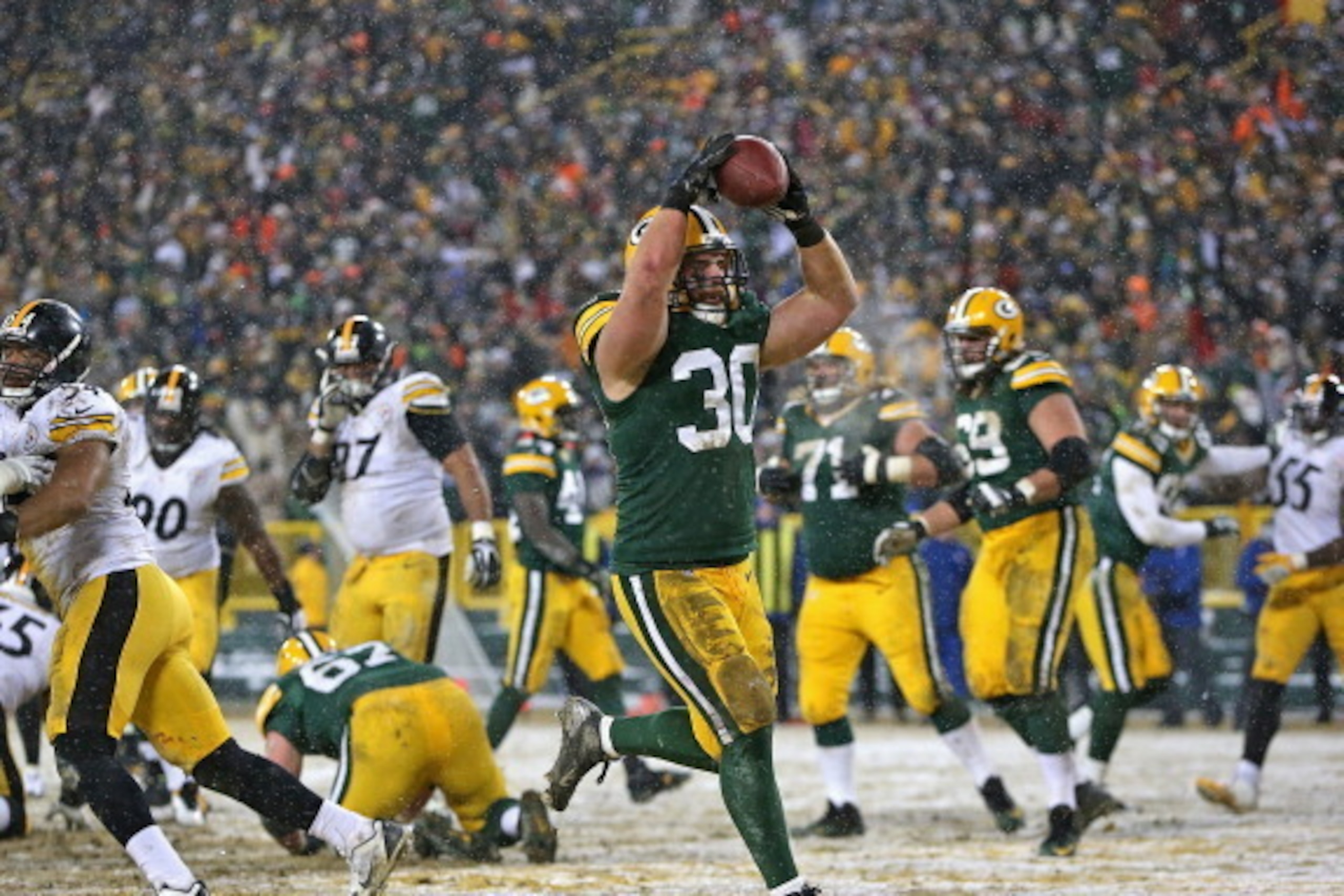 GREEN BAY, WI - DECEMBER 22: John Kuhn #30 of the Green Bay Packers scores a touchdown against the Pittsburgh Steelers at Lambeau Field on December 22, 2013 in Green Bay, Wisconsin. The Steelers defeated the Packers 38-31. (Photo by Jonathan Daniel/Getty GREEN BAY, WI - DECEMBER 22: John Kuhn #30 of the Green Bay Packers scores a touchdown against the Pittsburgh Steelers at Lambeau Field on December 22, 2013 in Green Bay, Wisconsin. The Steelers defeated the Packers 38-31. (Photo by Jonathan Daniel/Getty