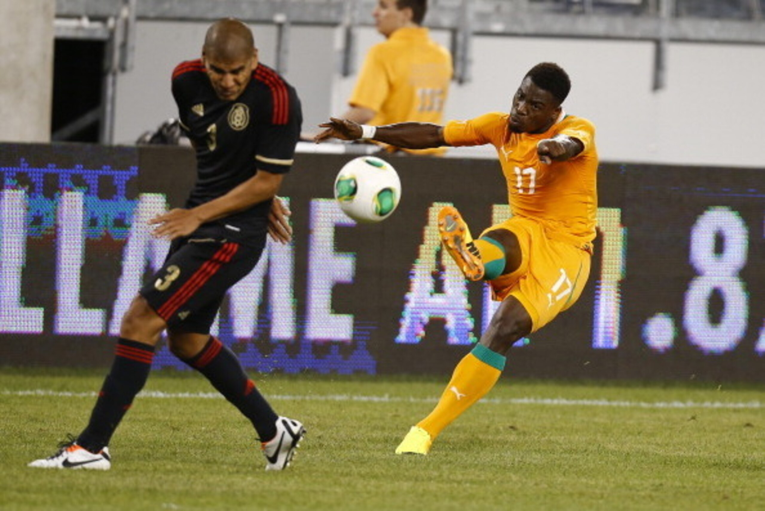 EAST RUTHERFORD, NJ - AUGUST 14:  Serge Aurier #17 of Ivory Coast kicks the ball into Carlos Salcido #3 of Mexico during their match at MetLife Stadium on August 14, 2013 in East Rutherford, New Jersey.  (Photo by Jeff Zelevansky/Getty Images)