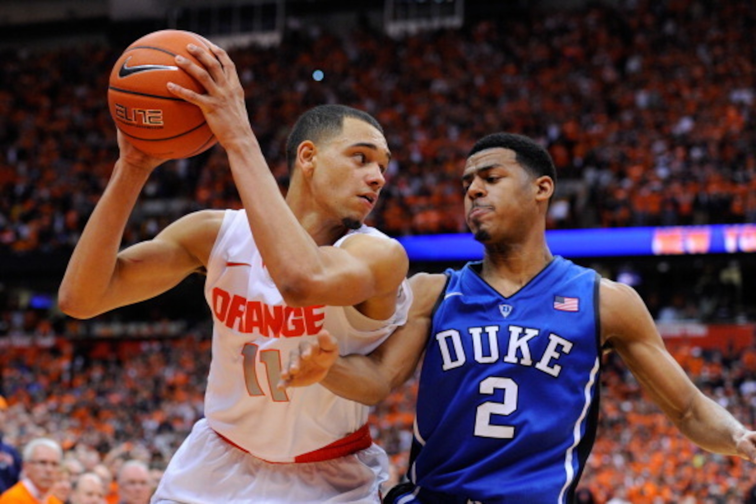 SYRACUSE, NY - FEBRUARY 01:  Quinn Cook #2 of the Duke Blue Devils reaches to knock the ball out of the hands of Tyler Ennis #11 of the Syracuse Orange during overtime at the Carrier Dome on February 1, 2014 in Syracuse, New York.  Syracuse defeated Duke 