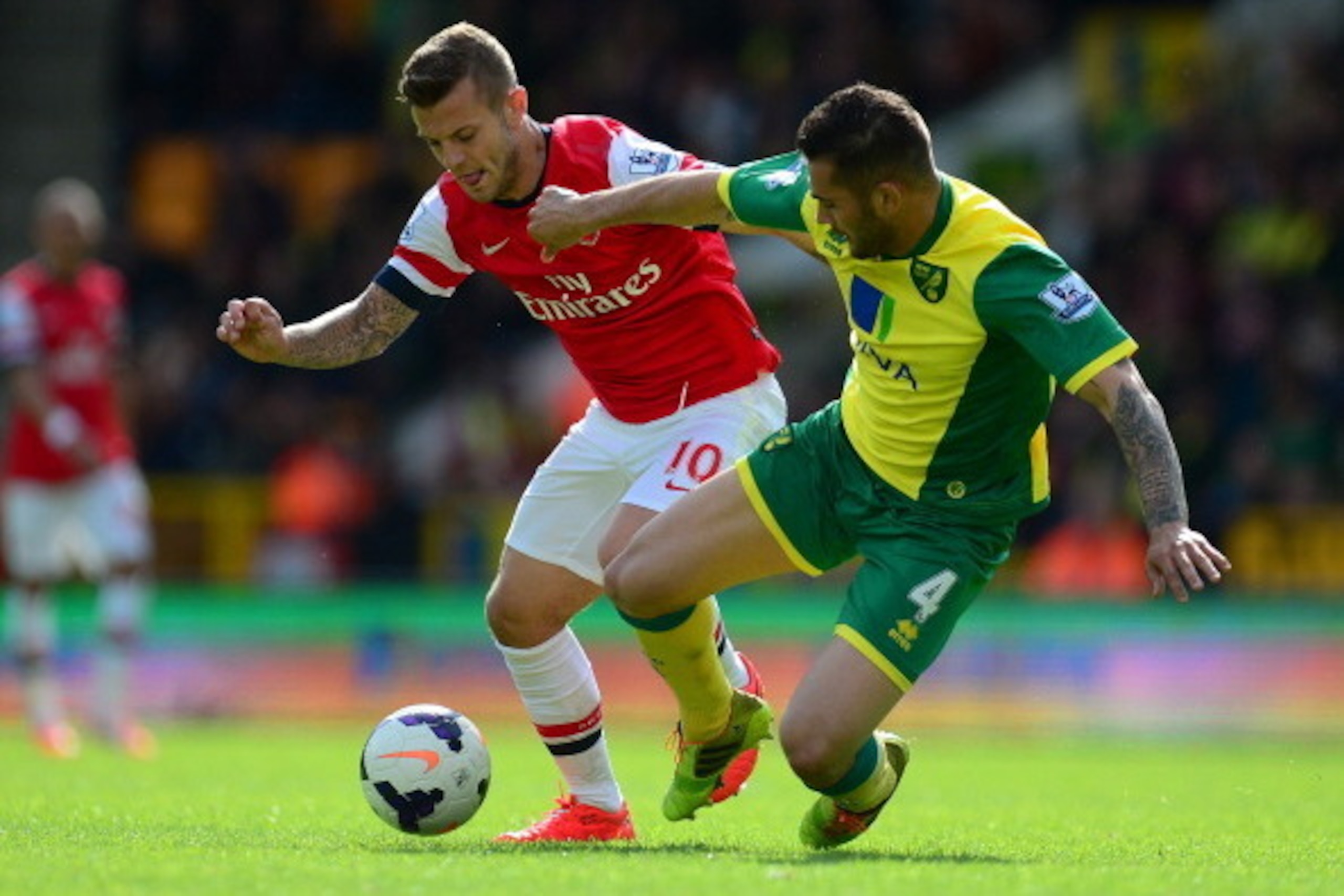 NORWICH, ENGLAND - MAY 11:  Jack Wilshere of Arsenal battles with Bradley Johnson of Norwich City during the Barclays Premier League match between Norwich City and Arsenal at Carrow Road on May 11, 2014 in Norwich, England.  (Photo by Jamie McDonald/Getty