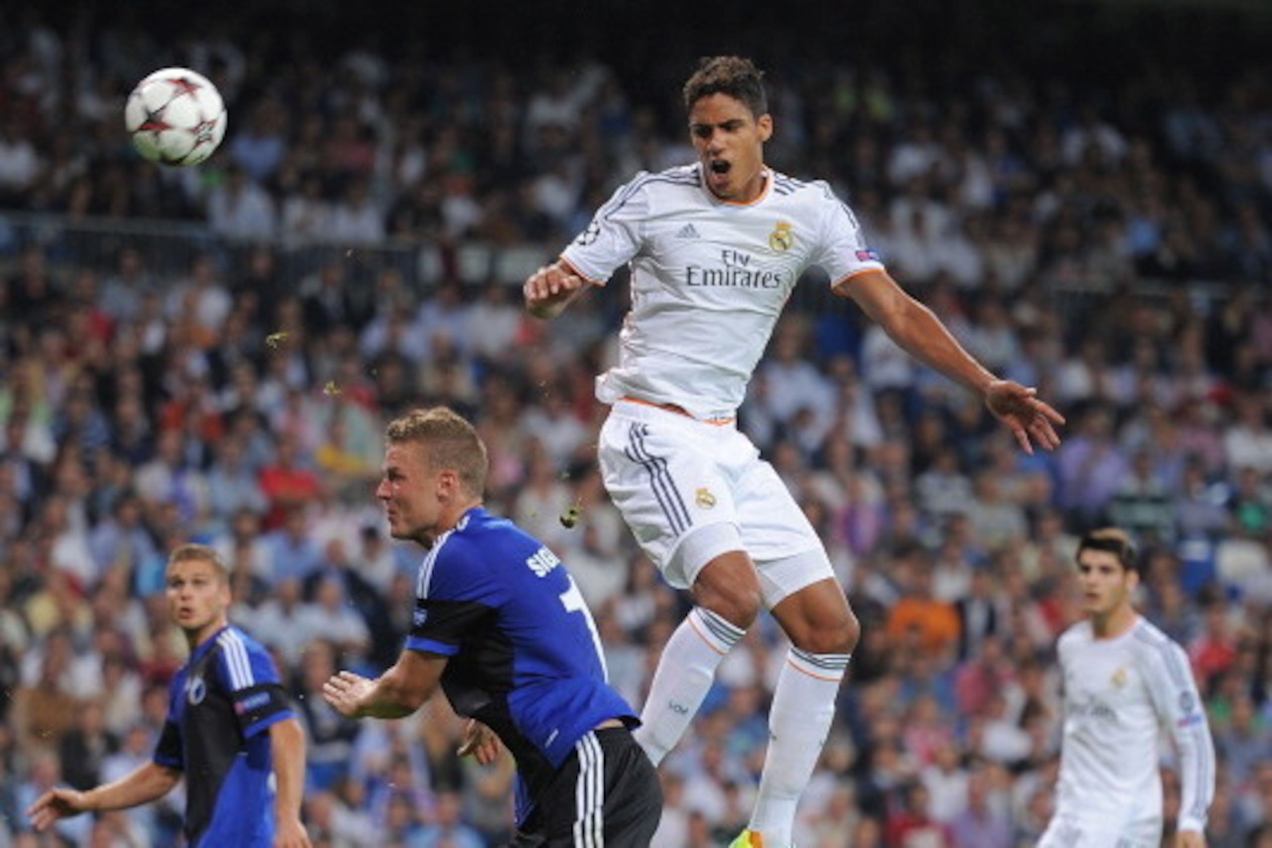 MADRID, SPAIN - OCTOBER 02:  Raphael Varane (R) of Real Madrid CF heads the ball beside Ragnar Sigurdsson of FC Copenhagen during the UEFA Champions League match between Real Madrid CF and FC Copenhagen at Estadio Santiago Bernabeu on October 2, 2013 in M