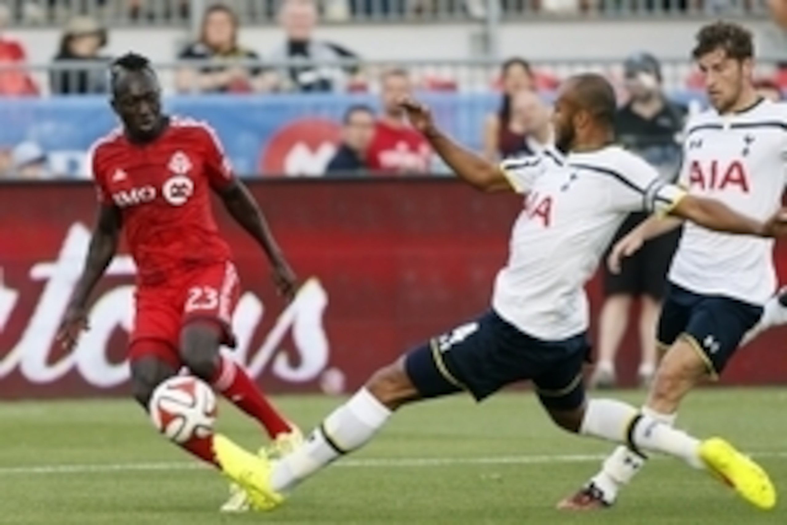 Jul 23, 2014; Toronto, Ontario, Canada; Tottenham Hotspur defender Younes Kaboul (4) knocks the ball away from Toronto FC midfielder Dominic Oduro (23) during the first half at BMO Field. Mandatory Credit: John E. Sokolowski-USA TODAY Sports