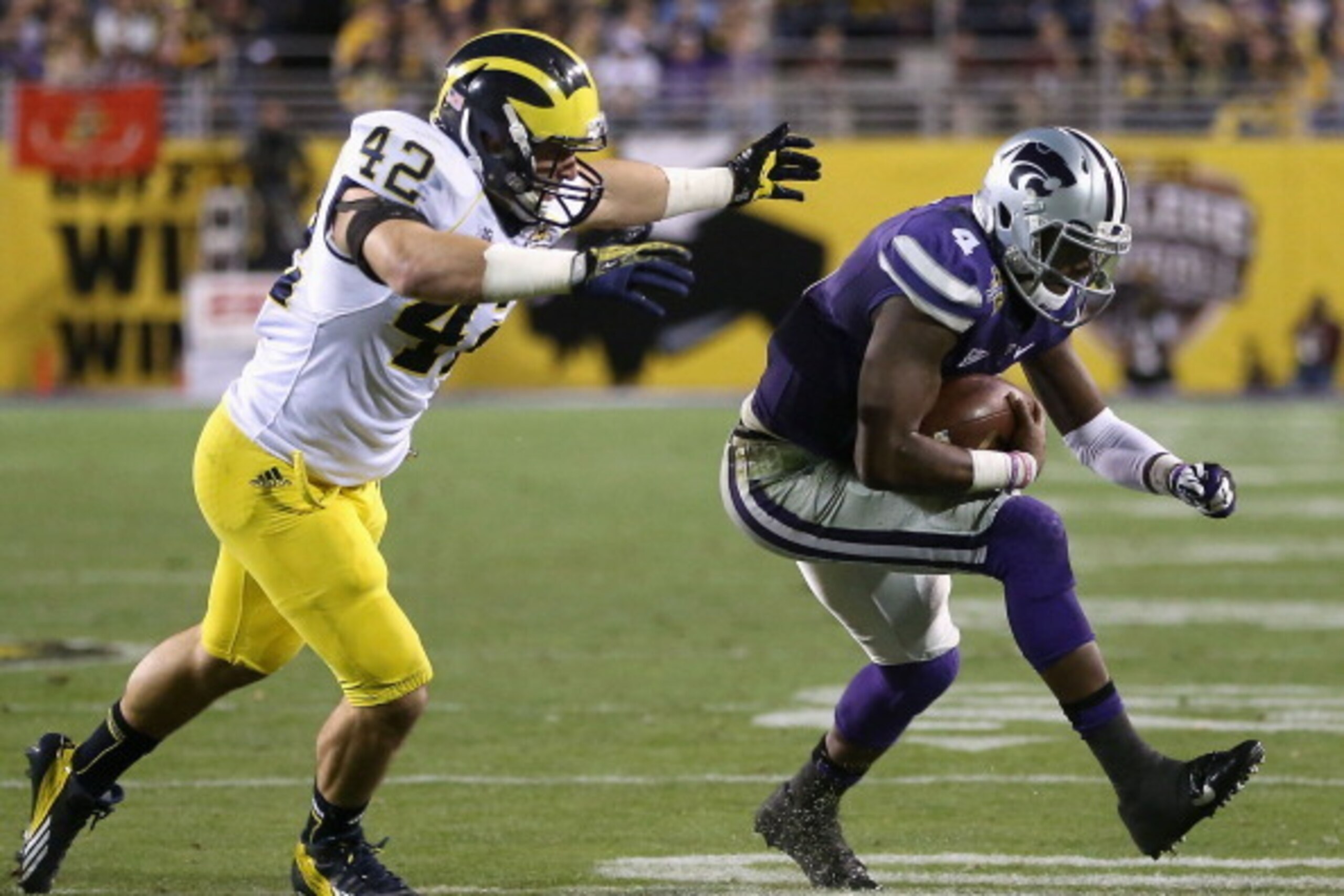 TEMPE, AZ - DECEMBER 28:  Quarterback Daniel Sams #4 of the Kansas State Wildcats runs with the football past linebacker Ben Gedeon #42 of the Michigan Wolverines during the Buffalo Wild Wings Bowl at Sun Devil Stadium on December 28, 2013 in Tempe, Arizo
