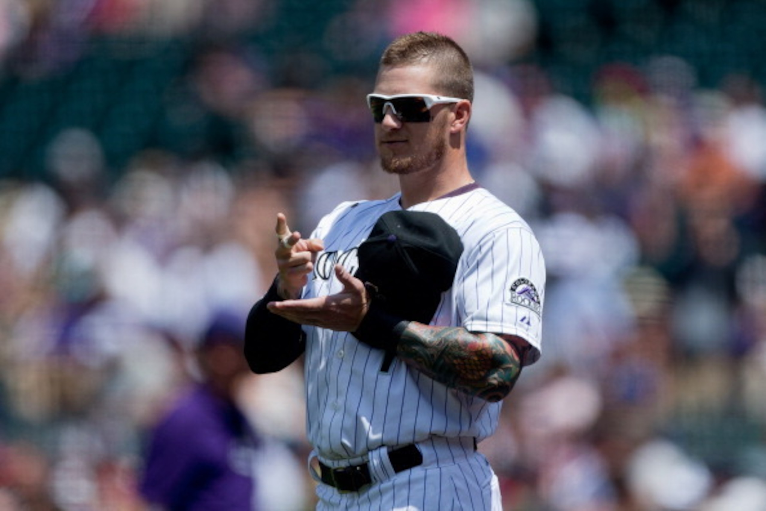 DENVER, CO - JULY 23:  Brandon Barnes #1 of the Colorado Rockies plays paper, rock, scissors with a member of the Washington Nationals during a friendly standoff before the game started at Coors Field on July 23, 2014 in Denver, Colorado. (Photo by Justin