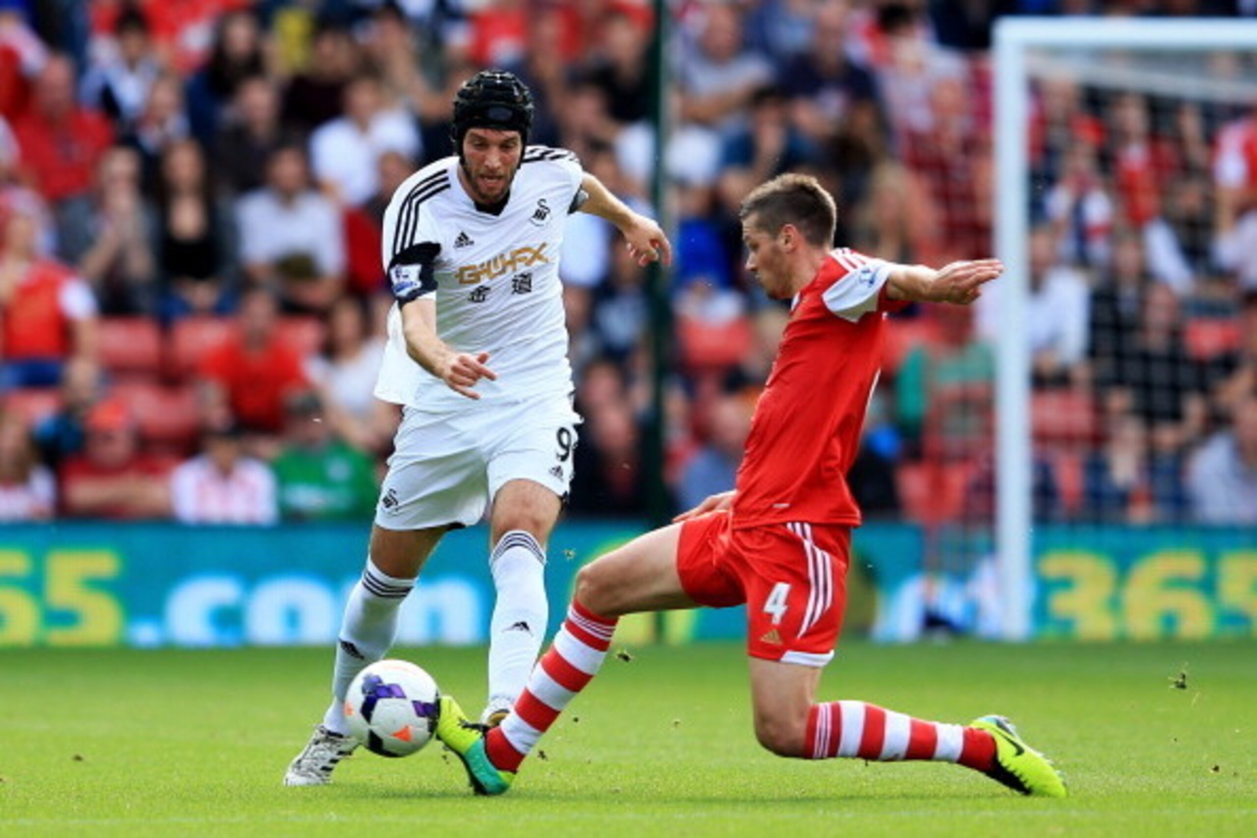 SOUTHAMPTON, ENGLAND - OCTOBER 06:  Miguel Michu of Swansea City is tackled by Morgan Schneiderlin of Southampton during the Barclays Premier League match between Southampton and Swansea City at St Mary's Stadium on October 6, 2013 in Southampton, England
