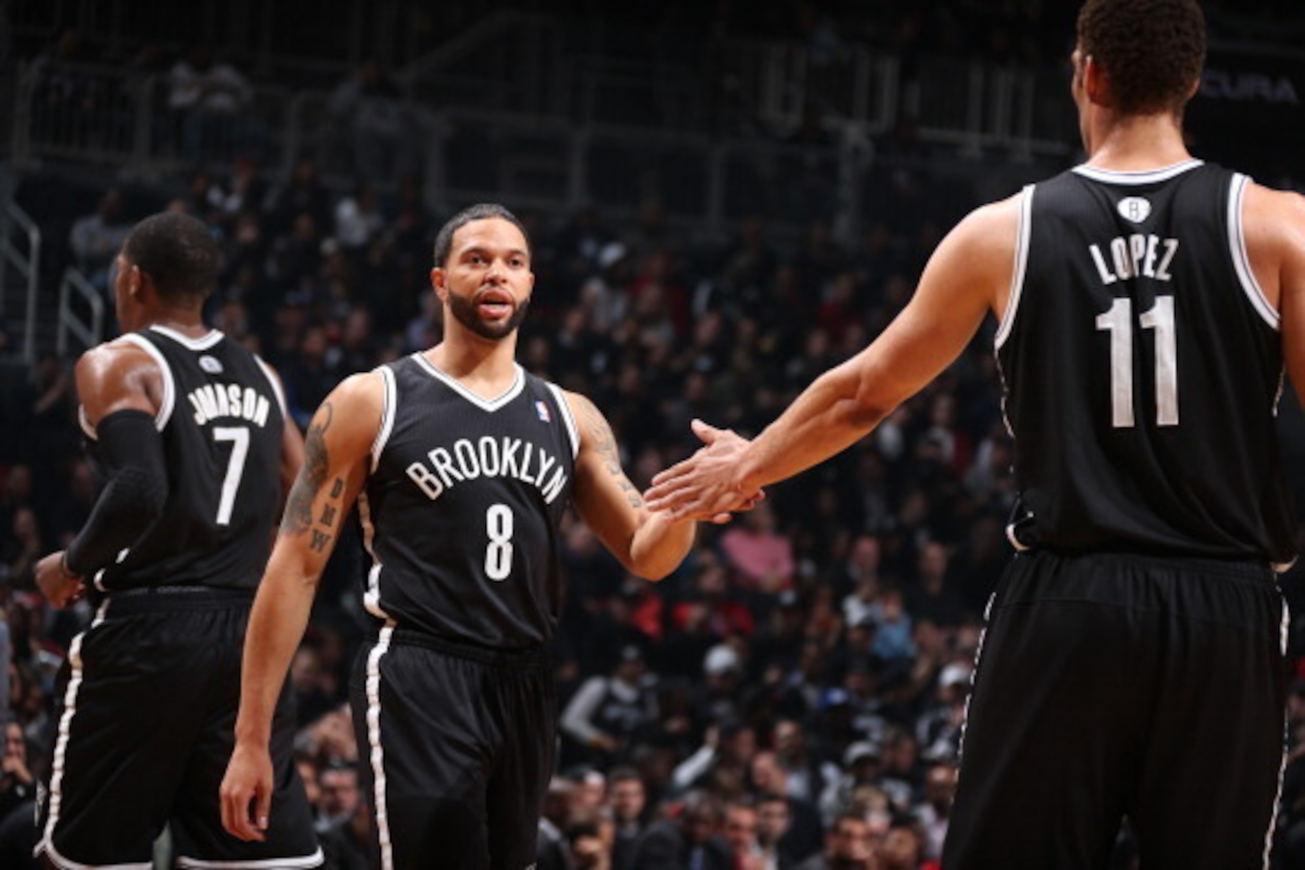 BROOKLYN, NY - APRIL 20: Deron Williams #8 of the Brooklyn Nets high-fives teammate Brook Lopez #11 in Game One of the Eastern Conference Quarterfinals against the Chicago Bulls during the 2013 NBA Playoffs on April 20 at the Barclays Center in the Brookl