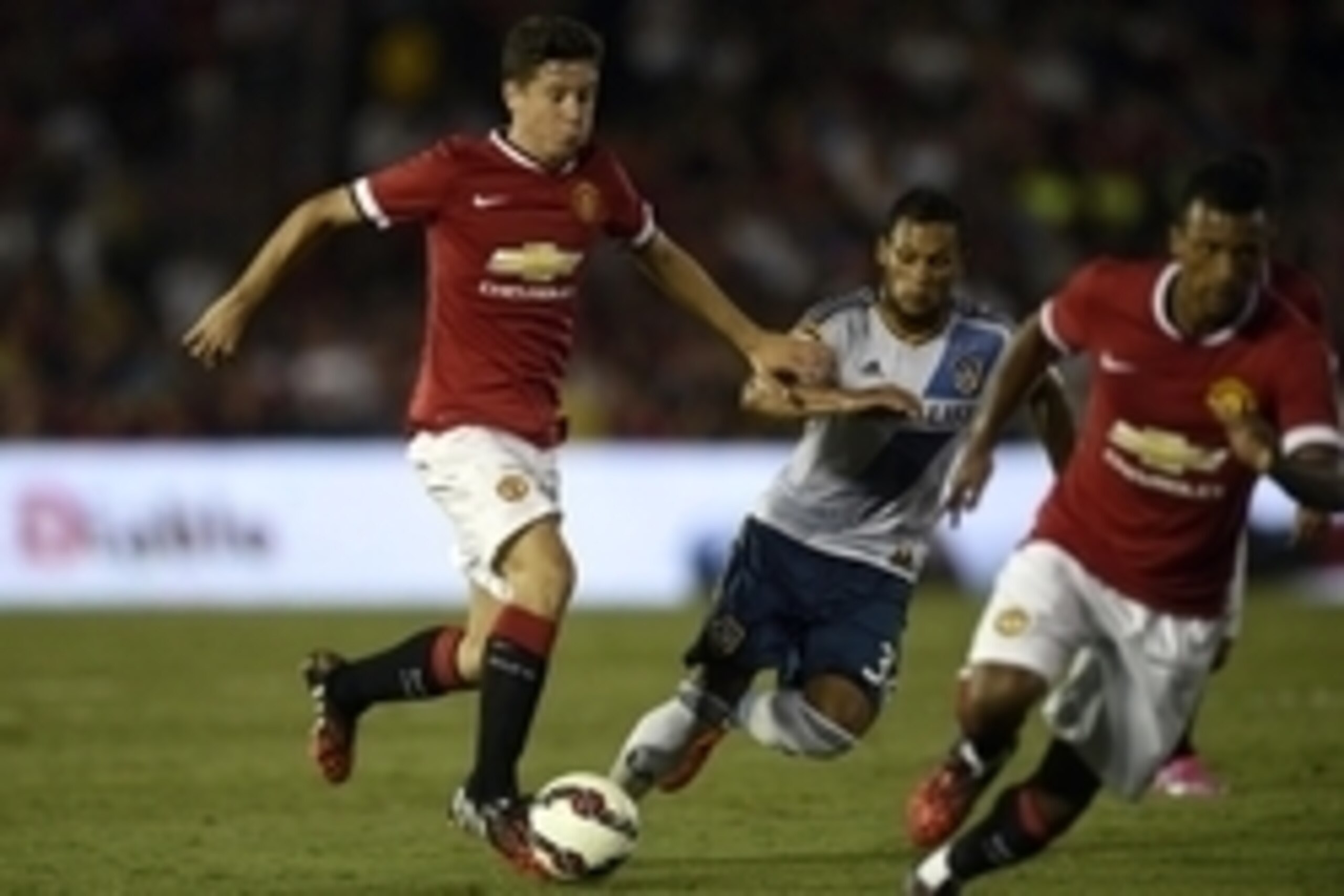 Jul 23, 2014; Pasadena, CA, USA; Manchester United midfielder Ander Herrera (21) moves the ball down the field defended by Los Angeles Galaxy midfielder Kenney Walker (34) during the second half at Rose Bowl. Manchester United defeated Los Angeles Galaxy 