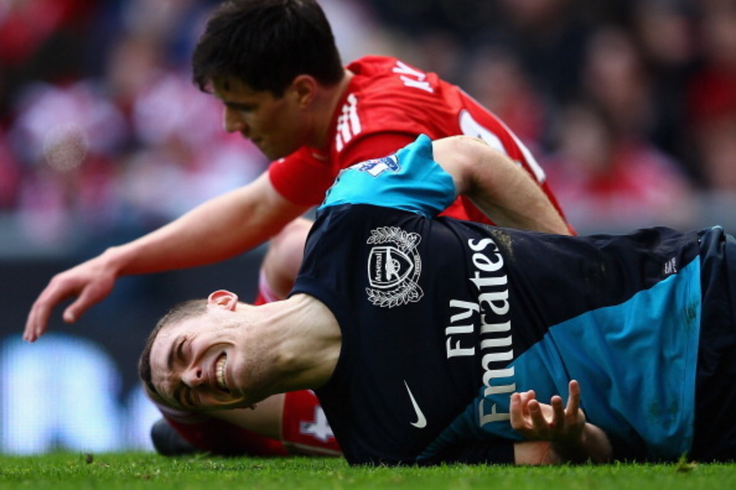 LIVERPOOL, ENGLAND - MARCH 03:  Thomas Vermaelen of Arsenal lies injured on the pitch during the Barclays Premier League match between Liverpool and Arsenal at Anfield on March 3, 2012 in Liverpool, England.  (Photo by Clive Mason/Getty Images)