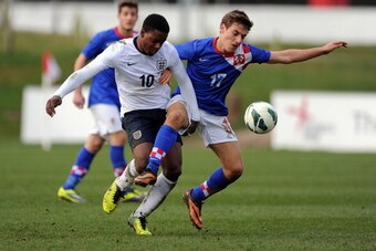 BURTON UPON TRENT, ENGLAND - MARCH 5:  Jermaine Anderson (L) of England and Nikola Vlasic of Croatia battle for the ball during the U18 International friendly match between England and Croatia at St Georges Park on March 5, 2014 in Burton upon Trent, Engl