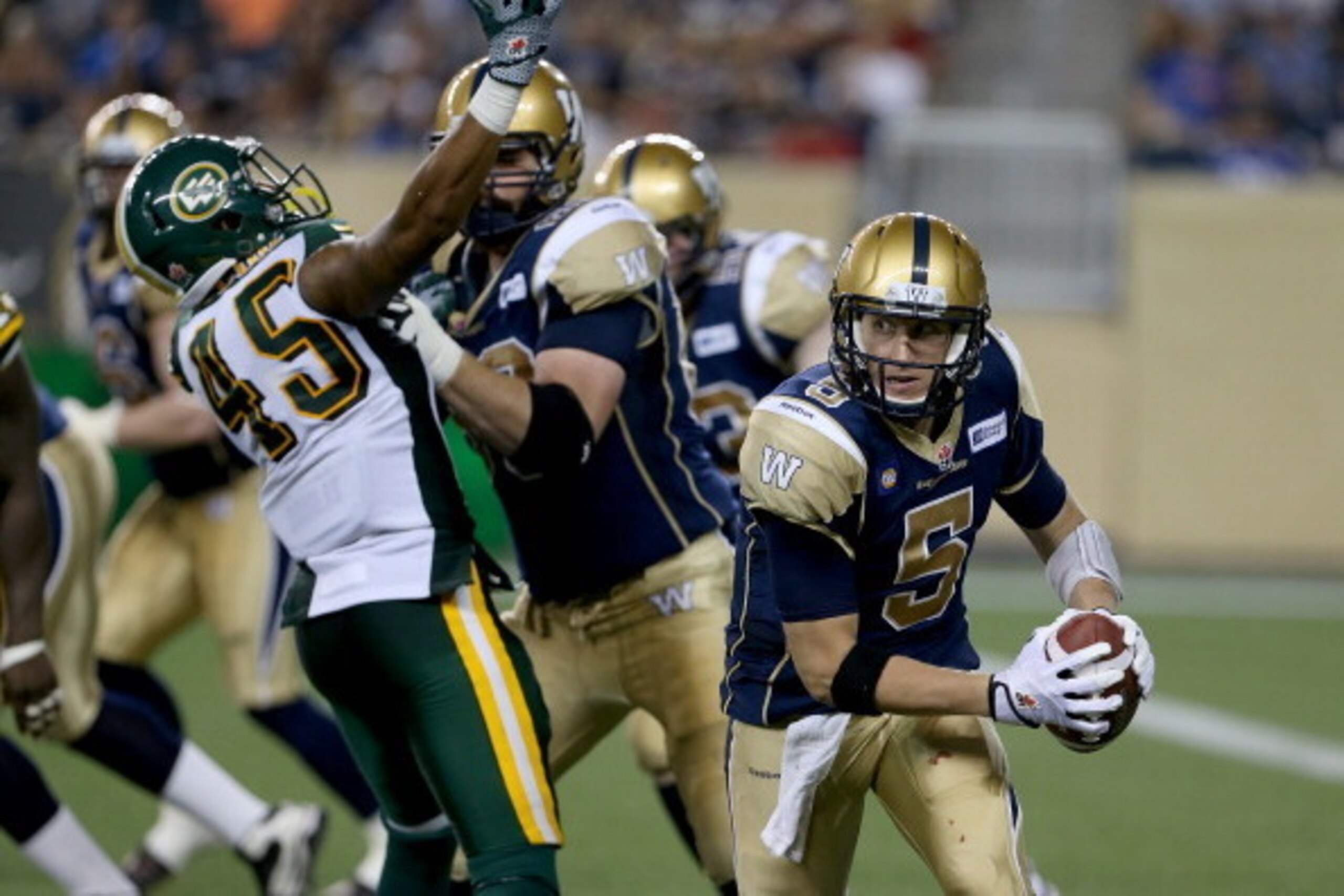 WINNIPEG, CANADA - July 17: Winnipeg Blue Bombers' quarterback Drew Willy (5) scrambles against the Edmonton Eskimos' during second half CFL Football at Investors Group Field in Winnipeg, Manitoba, Canada. (Photo by Trevor Hagan/Getty Images)