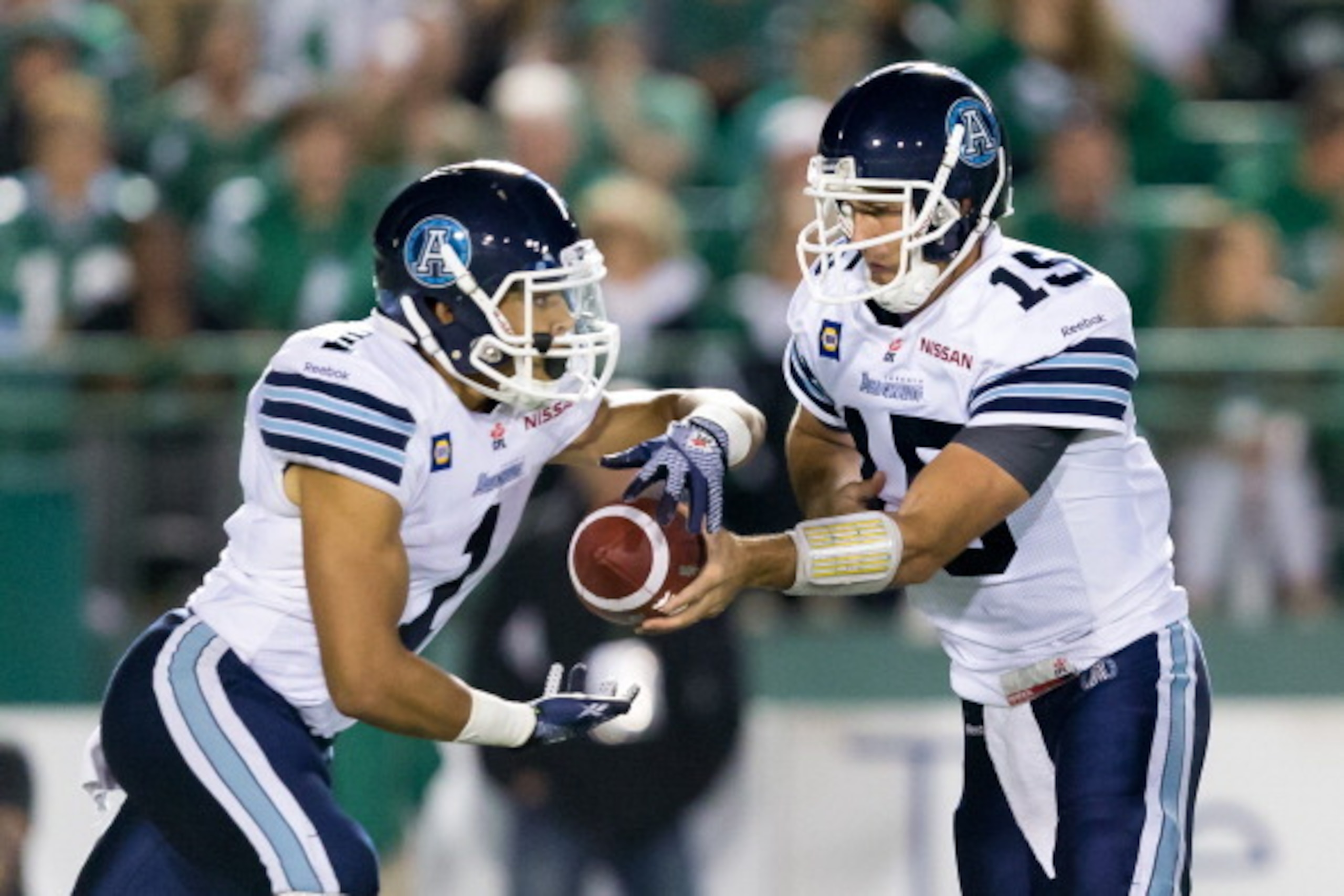 REGINA, SK, CANADA - JULY 26: Ricky Ray #15 hands the ball to Anthony Coombs #1 of the Toronto Argonauts in a game between the Toronto Argonauts and Saskatchewan Roughriders in week 5 of the 2014 CFL season at Mosaic Stadium on July 26, 2014 in Regina, Sa