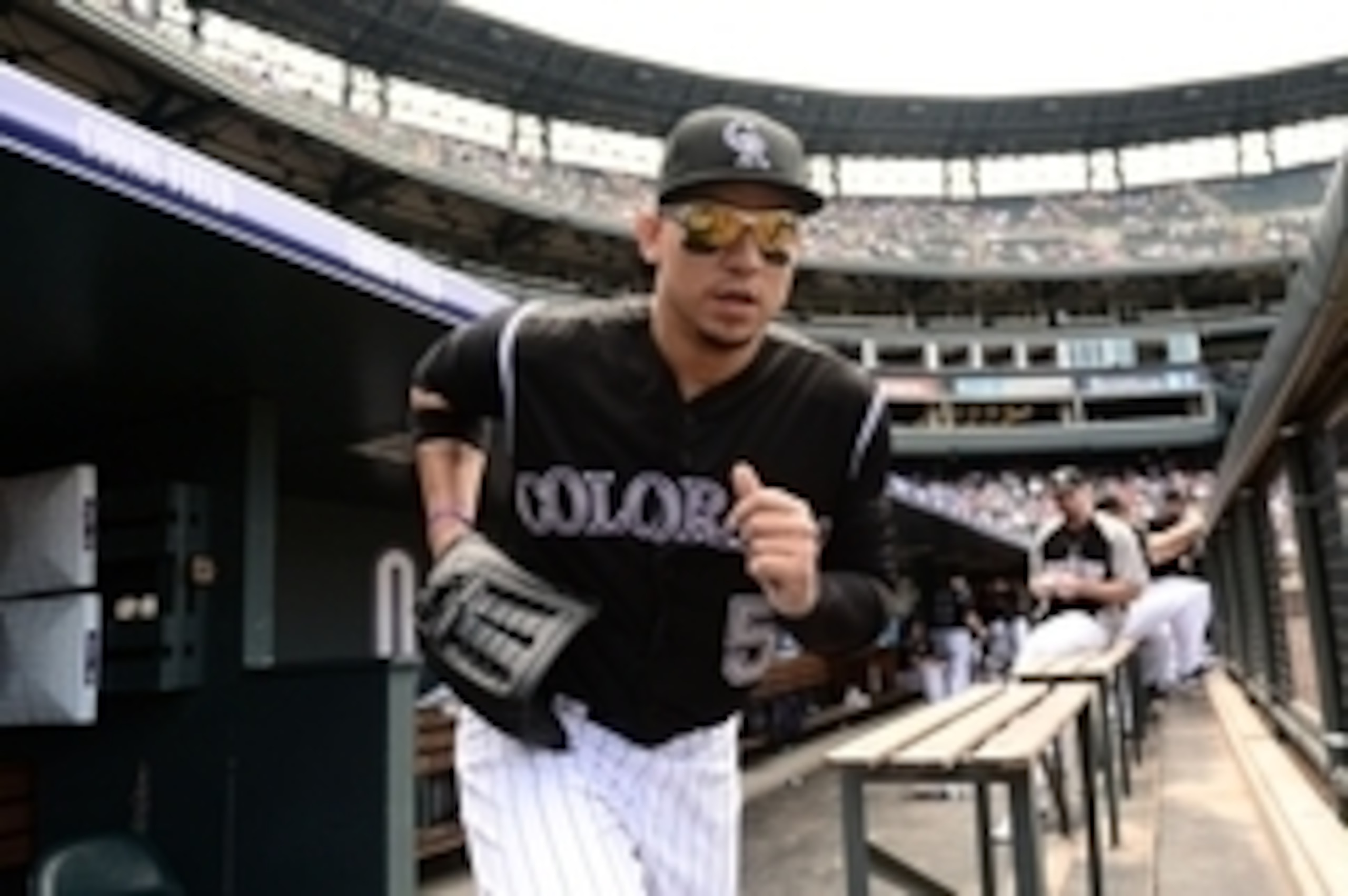 Jul 12, 2014; Denver, CO, USA; Colorado Rockies left fielder Carlos Gonzalez (5) takes to the field before the start of the game against the Minnesota Twins at Coors Field. The Twins defeated the Rockies 9-3. Mandatory Credit: Ron Chenoy-USA TODAY Sports