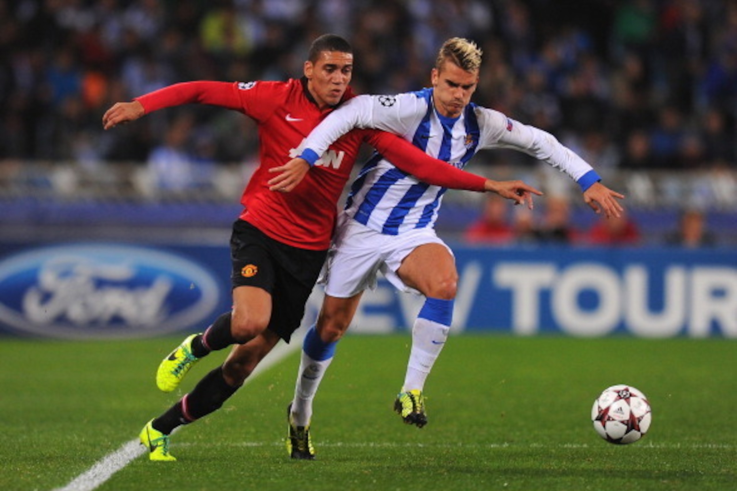 SAN SEBASTIAN, SPAIN - NOVEMBER 05:  Chris Smalling of Manchester United battles with Antoine Griezmann of Real Sociedad during the UEFA Champions League Group A match between Real Sociedad and Manchester United at Estadio Anoeta on November 5, 2013 in Sa