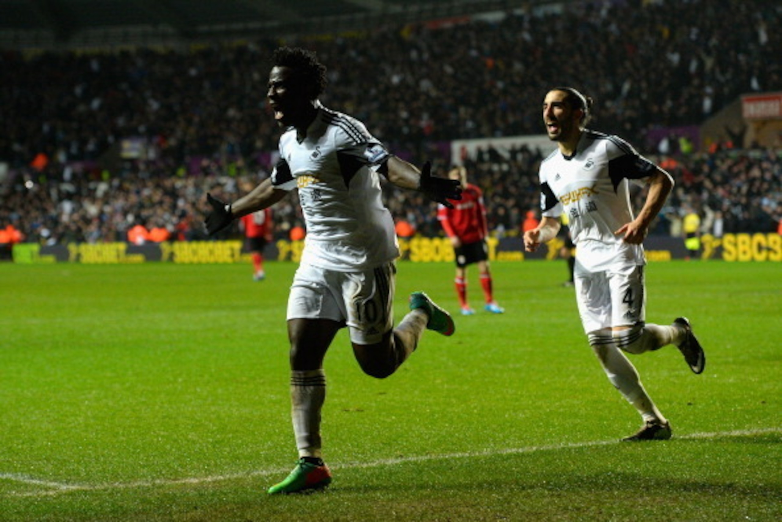 SWANSEA, WALES - FEBRUARY 08:  Swansea striker Wilfried Bony (l) celebrates with Chico Flores after scoring the third goal during the Barclays Premier League match between Swansea City and Cardiff City at Liberty Stadium on February 8, 2014 in Swansea, Wa