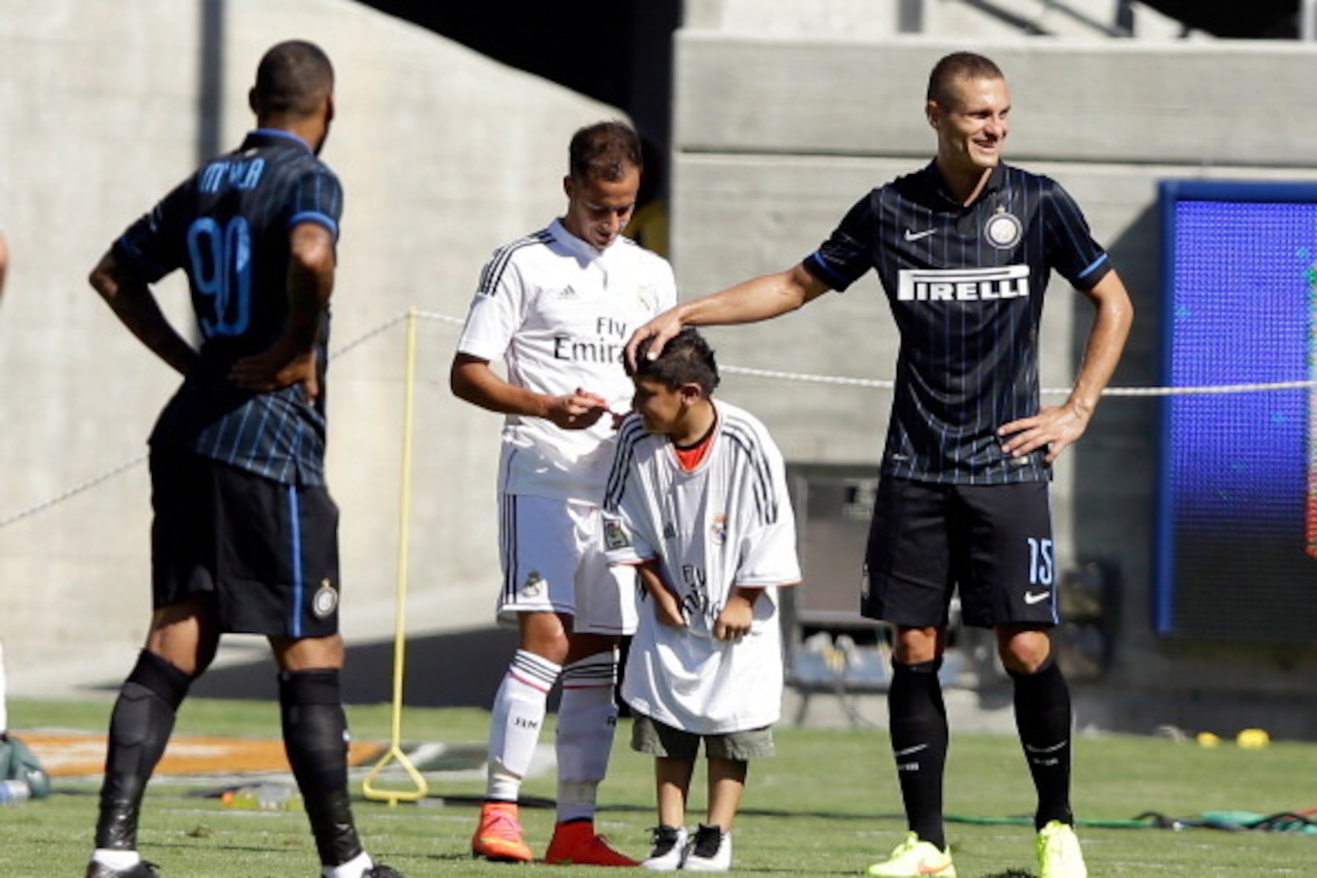 BERKELEY, CA - JULY 26:  Lucas Vazquez of Real Madrid signs an autograph for a young fan who ran onto the field while  Nemanja Vidic #15 of FC Internazionale rubs his head during their game in the International Champions Cup 2014 at California Memorial St