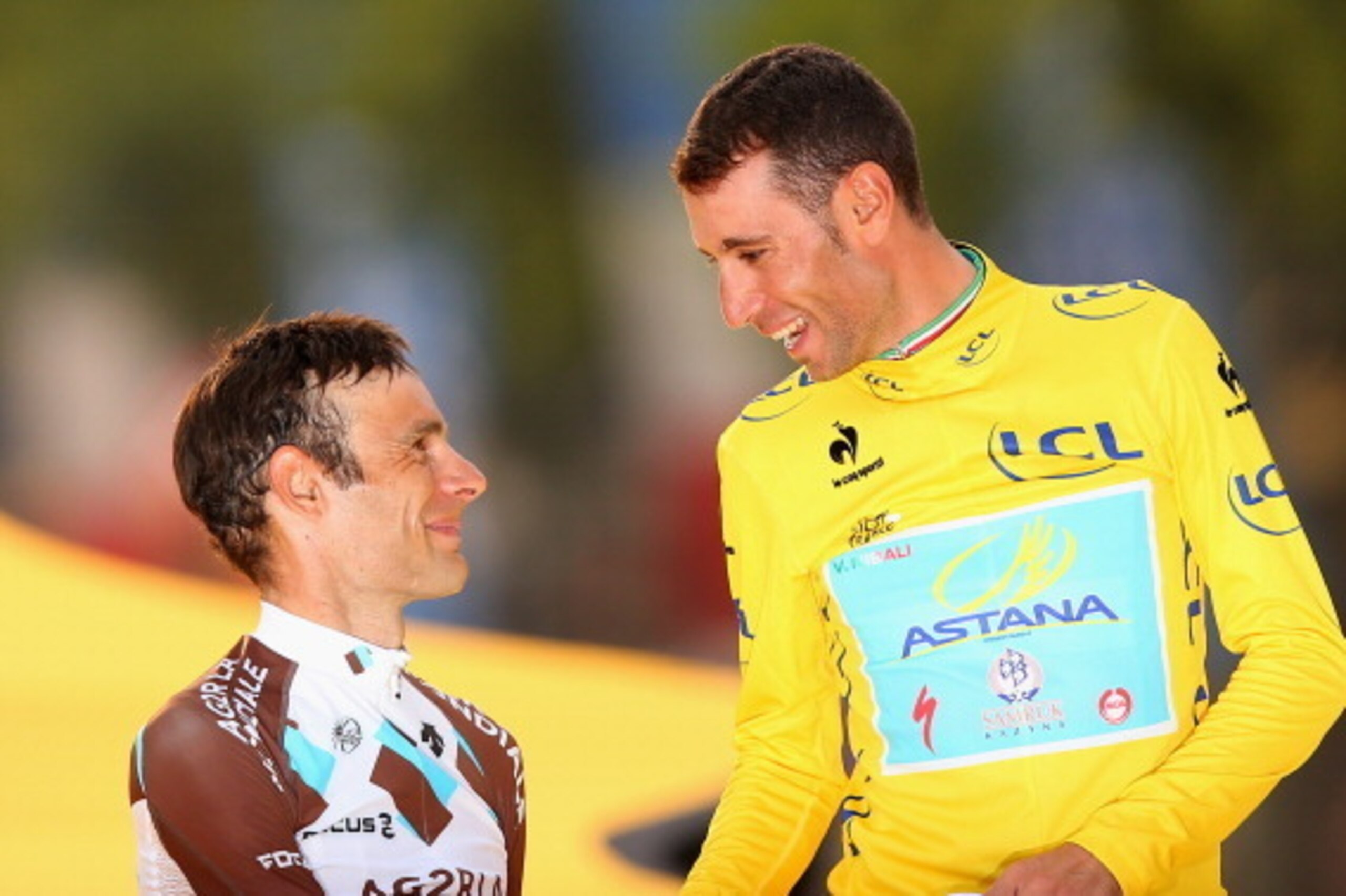 PARIS, FRANCE - JULY 27:  Vincenzo Nibali of Italy and Astana Pro Team is congratulated on his victory on the podium by second placed Jean-Christophe Peraud of France and and AG2R La Mondiale (L) following the twenty first stage of the 2014 Tour de France