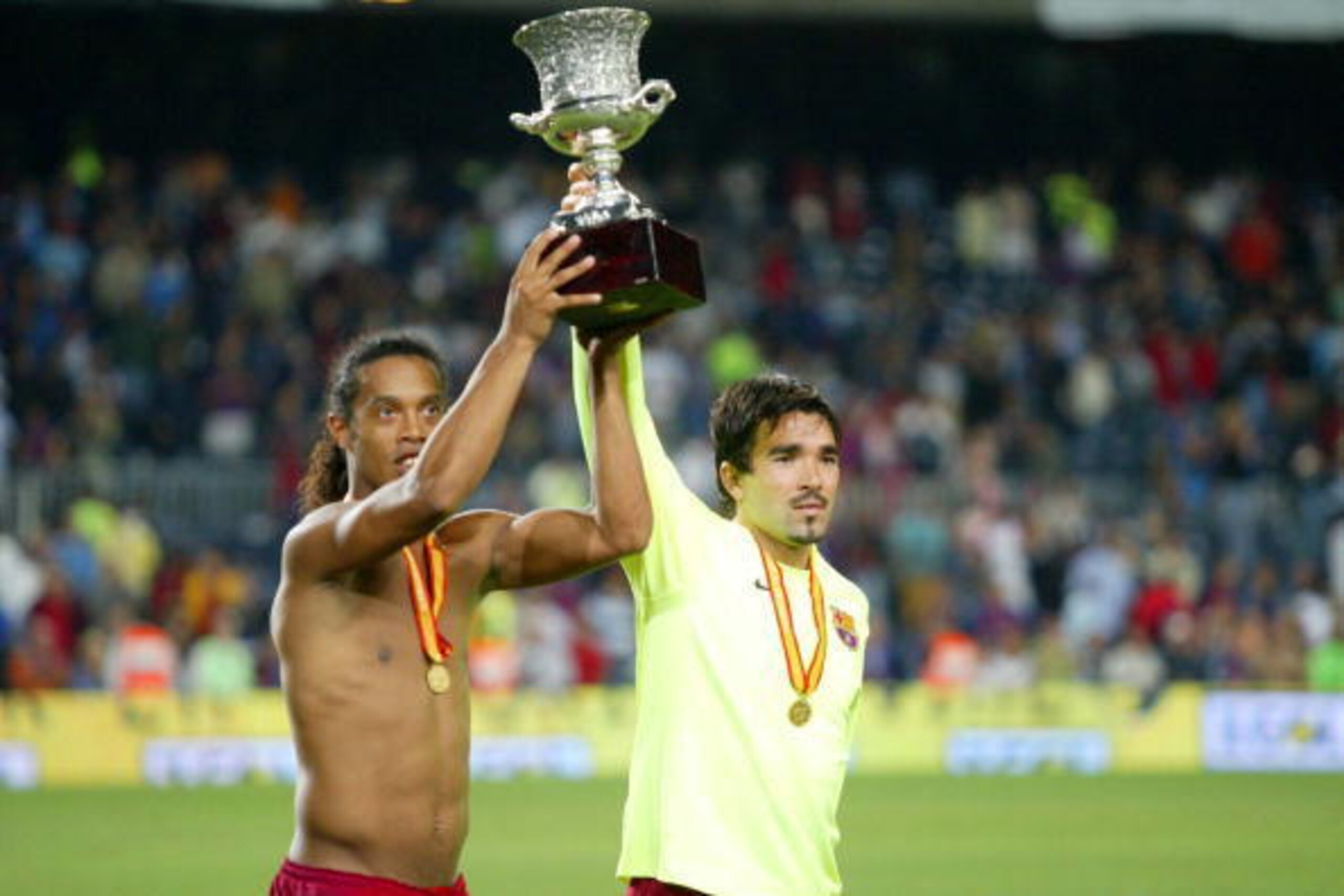 BARCELONA, SPAIN - AUGUST 20: Ronaldinho and Deco of FC Barcelona are seen with the trophy after winning the match between FC Barcelona and Real Betis during the Spain Supercup Final on August 20, 2005 at Camp Nou stadium in Barcelona, Spain.  (Photo by L