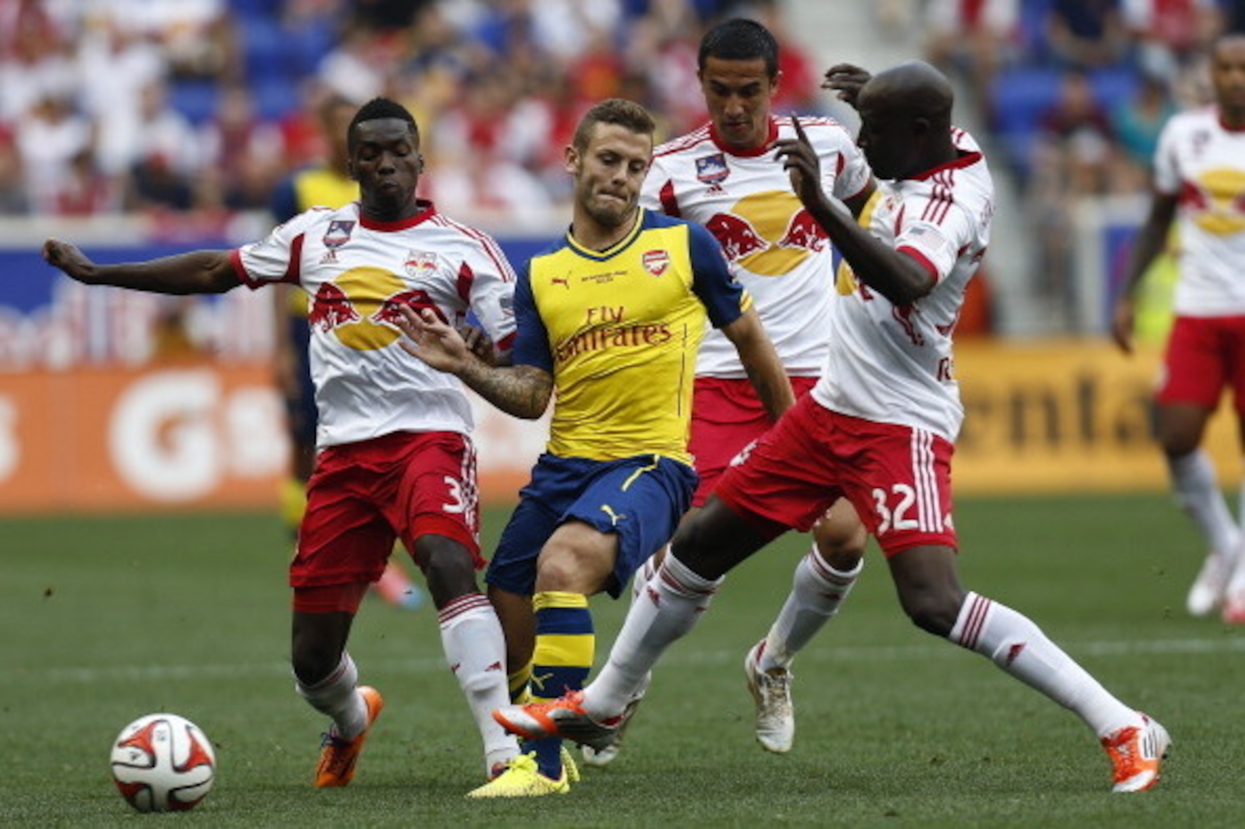 HARRISON, NJ - JULY 26:  Jack Wilshere #10 of Arsenal fights for the ball with Ibrahim Sekagya #32, Ambroise Oyongo #3 and Tim Cahill #17 of New York Red Bulls during their friendly match at Red Bull Arena on July 26, 2014 in Harrison, NJ. (Photo by Jeff 