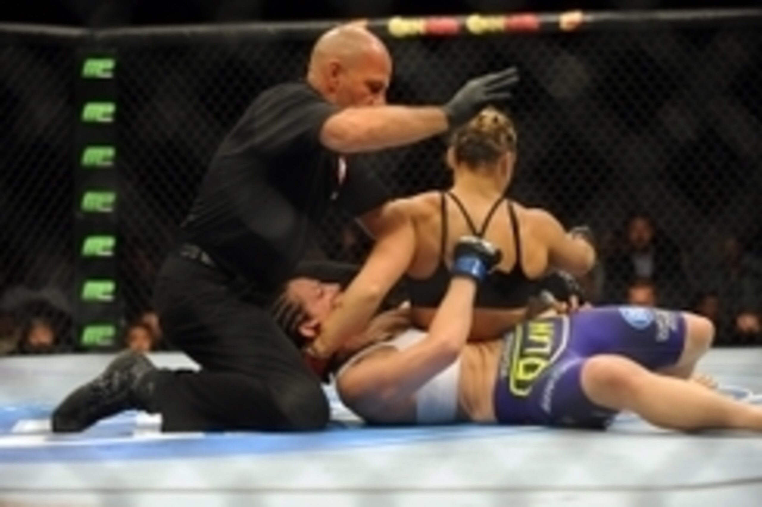 Jul 5, 2014; Las Vegas, NV, USA; The referee stops the fight during the first round after Alexis Davis (blue gloves) gets knocked out by Ronda Rousey (red gloves) during a bantamweight fight at Mandalay Bay Events Center. Mandatory Credit: Stephen R. Sylv