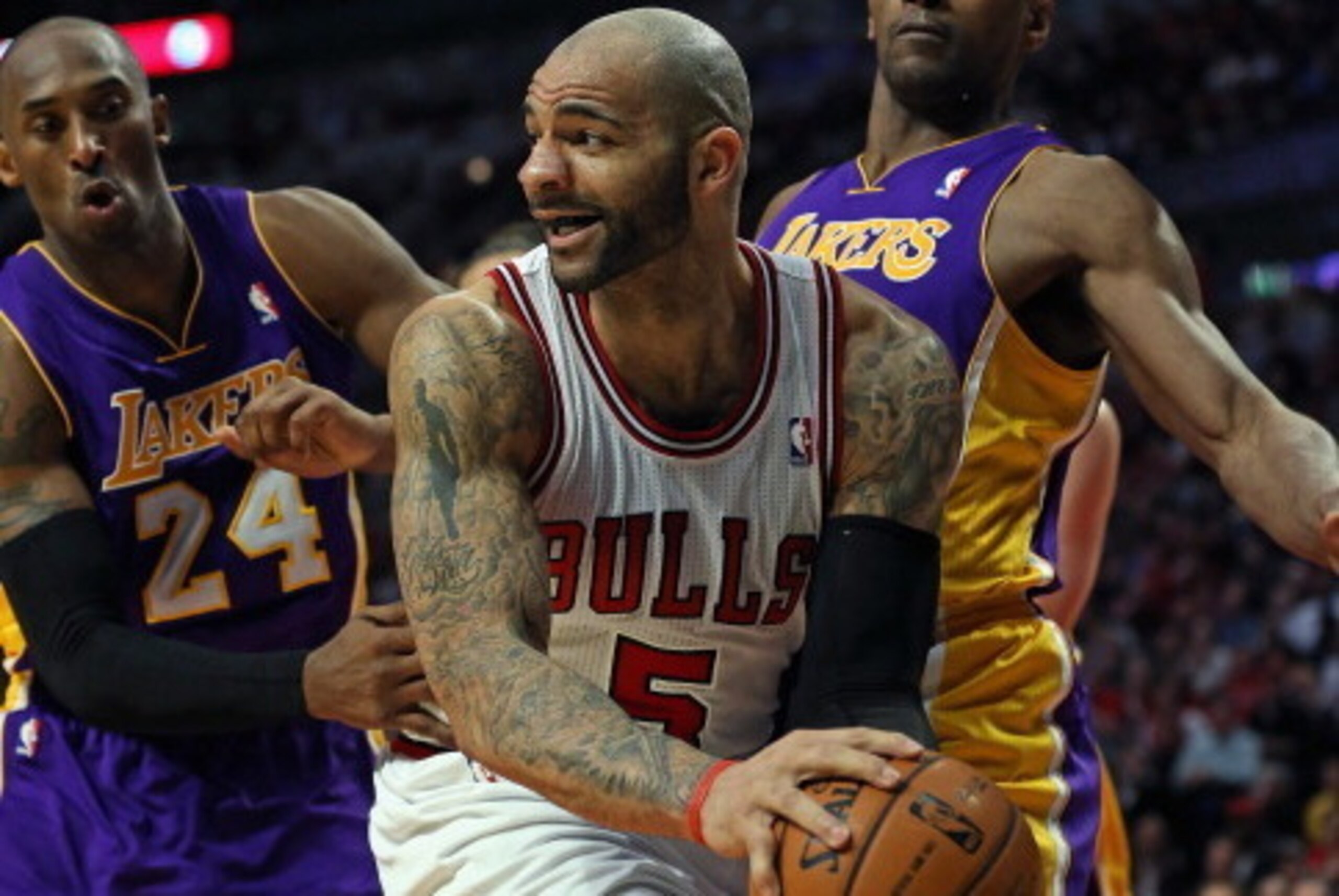 CHICAGO, IL - JANUARY 21: Carlos Boozer #5 of the Chicago Bulls looks to pass under pressure from Kobe Bryant #24 and Metta World Peace #15 of the Los Angeles Lakers at the United Center on January 21, 2013 in Chicago, Illinois. The Bulls defeated the Lak