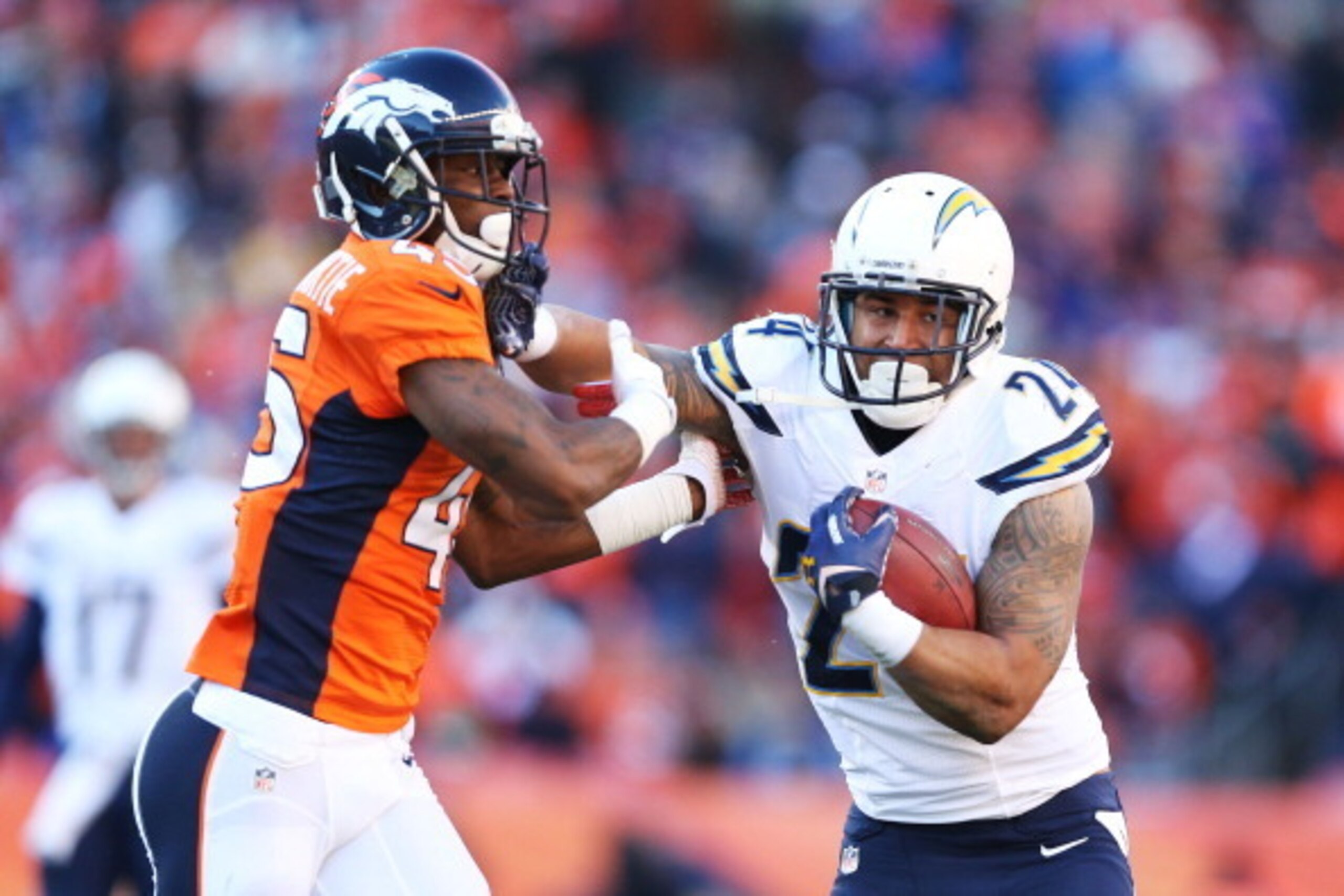 DENVER, CO - JANUARY 12:  Ryan Mathews #24 of the San Diego Chargers tries to avoid the tackle of  Dominique Rodgers-Cromartie #45 of the Denver Broncos during the AFC Divisional Playoff Game at Sports Authority Field at Mile High on January 12, 2014 in D