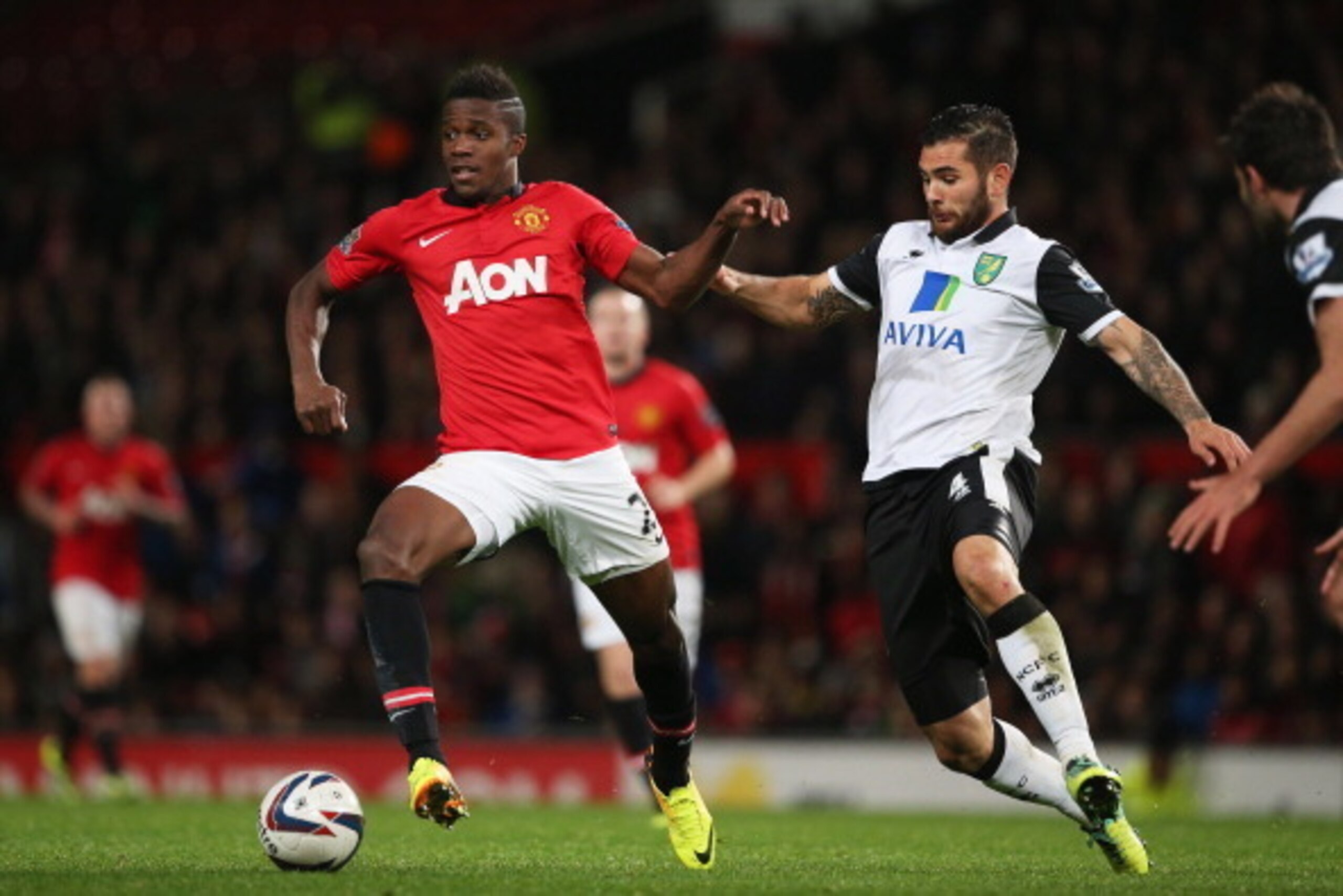 MANCHESTER, ENGLAND - OCTOBER 29: Wilfried Zaha of Manchester United is challenged by Bradley Johnson of Norwich City during the Capital One Cup fourth round match between Manchester United and Norwich City at Old Trafford on October 29, 2013 in Manchest MANCHESTER, ENGLAND - OCTOBER 29: Wilfried Zaha of Manchester United is challenged by Bradley Johnson of Norwich City during the Capital One Cup fourth round match between Manchester United and Norwich City at Old Trafford on October 29, 2013 in Manchest