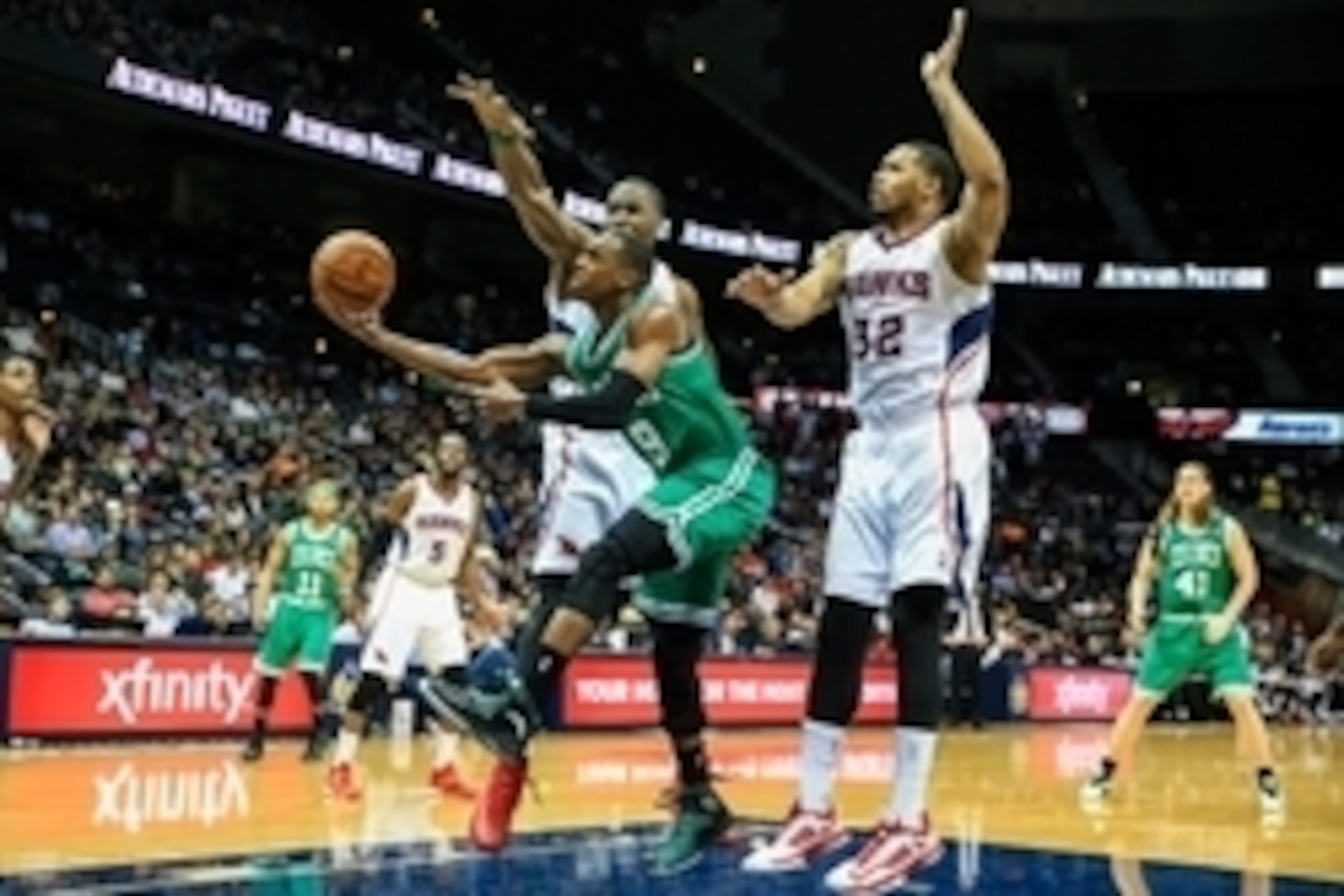 Apr 9, 2014; Atlanta, GA, USA; Boston Celtics guard Rajon Rondo (9) attempts a shot between Atlanta Hawks forward Elton Brand (42) and forward Mike Scott (32) in the first quarter at Philips Arena. Mandatory Credit: Daniel Shirey-USA TODAY Sports