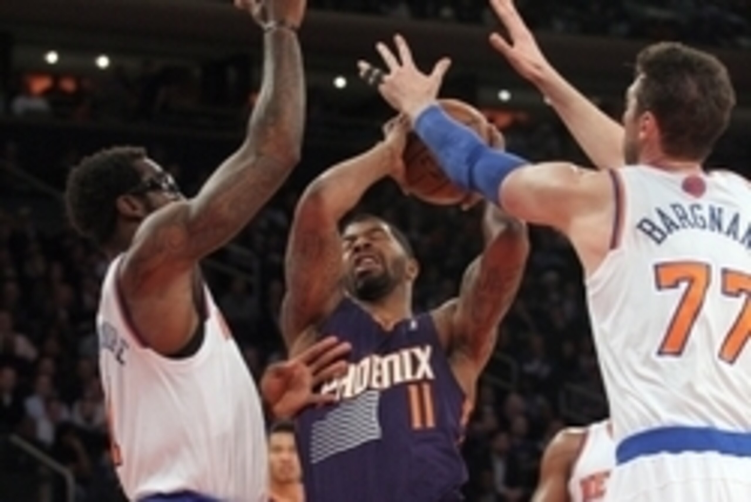 Jan 13, 2014; New York, NY, USA; Phoenix Suns power forward Markieff Morris (11) grabs a rebound between New York Knicks power forward Amar'e Stoudemire (1) and New York Knicks power forward Andrea Bargnani (77) during the first quarter of a game at Madis