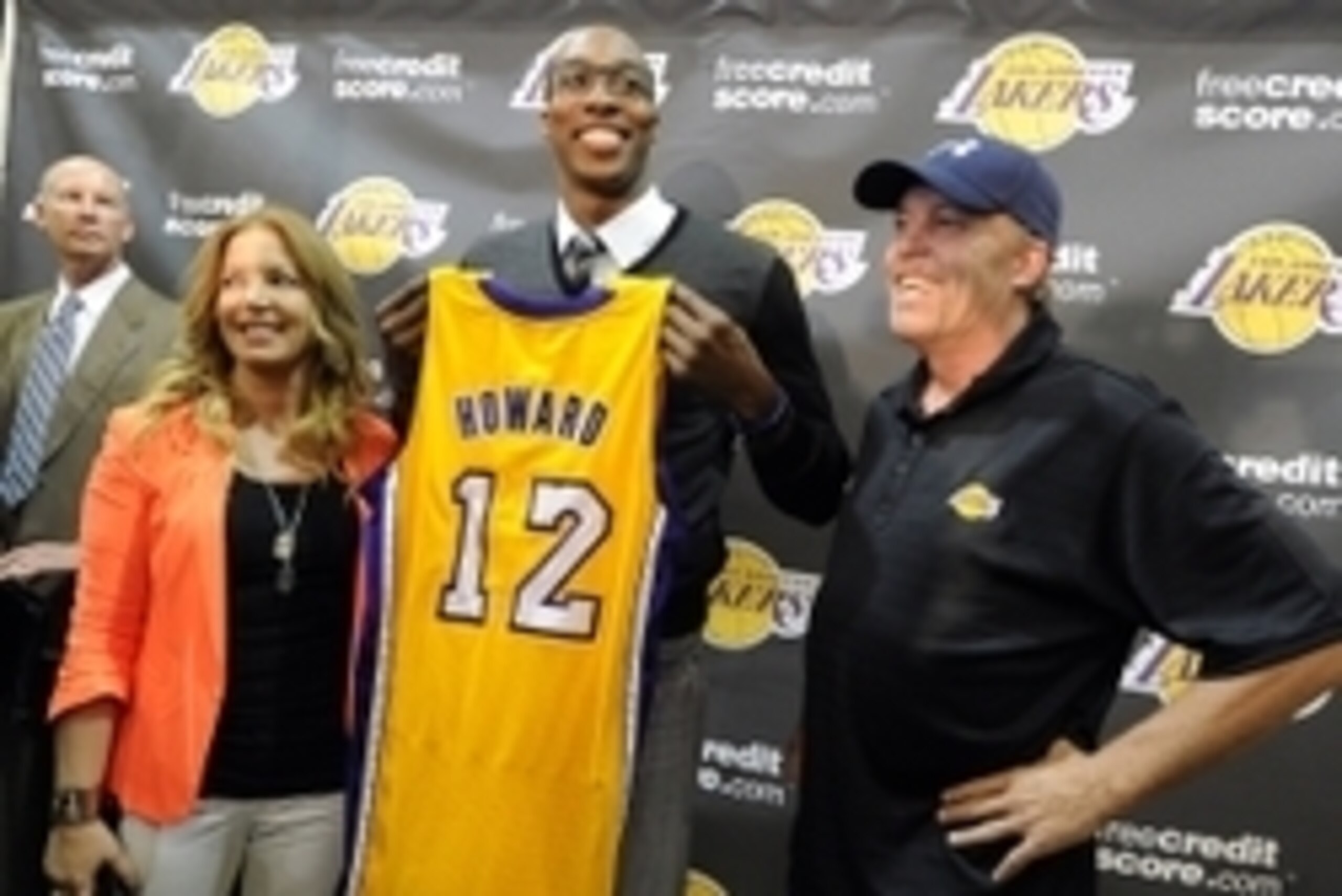 August 10, 2012; El Segundo, CA, USA;   Los Angeles Lakers center Dwight Howard stands between Jeanie Buss and Jim Buss as he holds his jersey during a press conference held to introduce the three-time defensive player of the year who was aquired in a fou