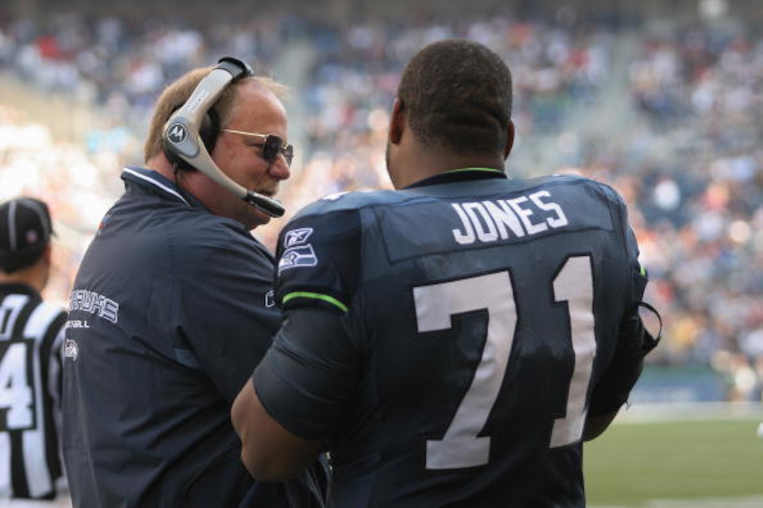 SEATTLE - SEPTEMBER 26:  Coach Mike Holmgren talks with Tackle Walter Jones #71 of the Seattle Seahawks on the sidelines during the game with the San Francisco 49ers at Qwest Field on September 26, 2004 in Seattle, Washington. The Seahawks won 34-0. (Phot