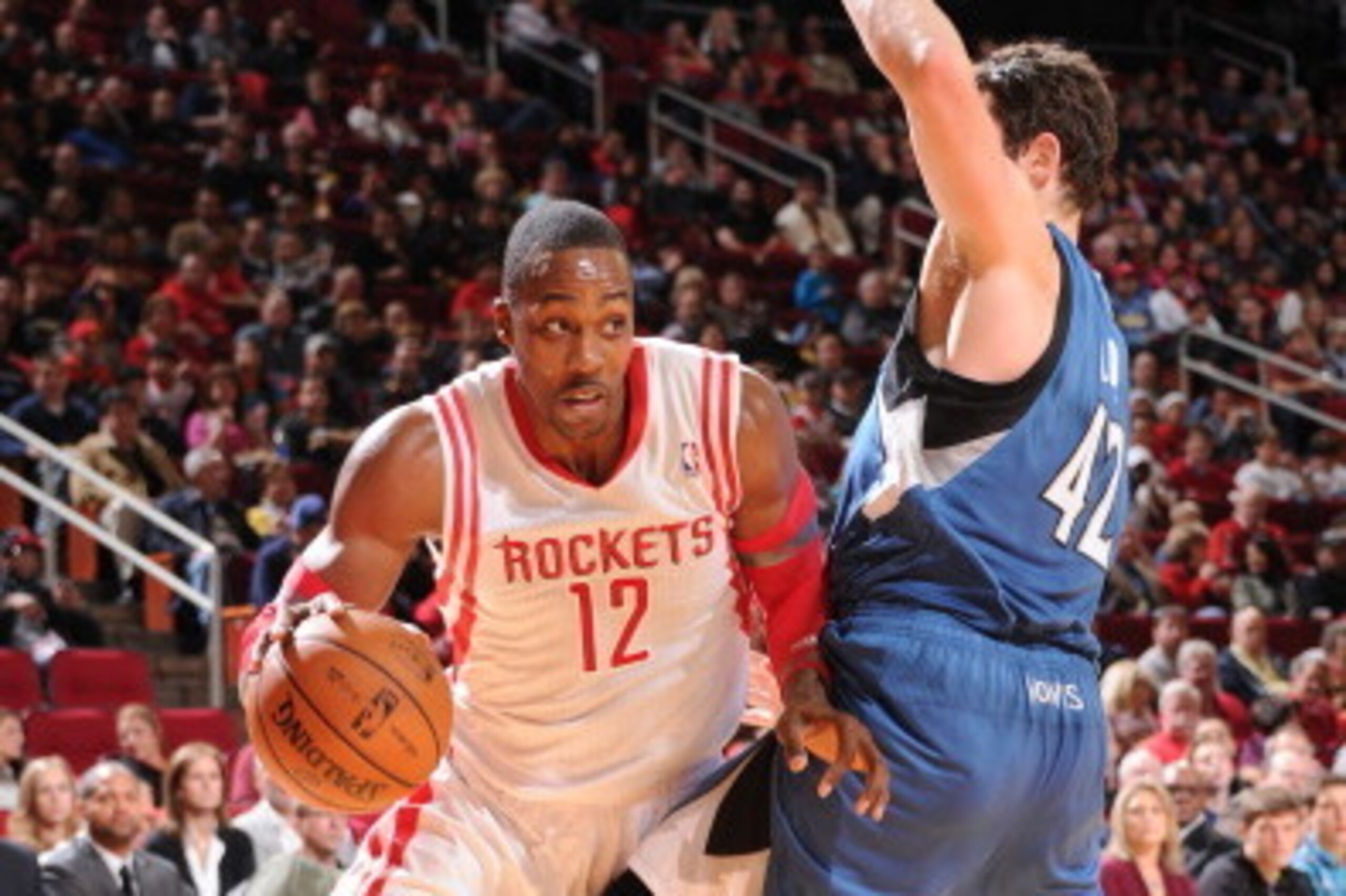 HOUSTON, TX - NOVEMBER 23:  Dwight Howard #12 of the Houston Rockets drives the ball against Kevin Love #42 of the Minnesota Timberwolves on November 23, 2013 at the Toyota Center in Houston, Texas. NOTE TO USER: User expressly acknowledges and agrees tha