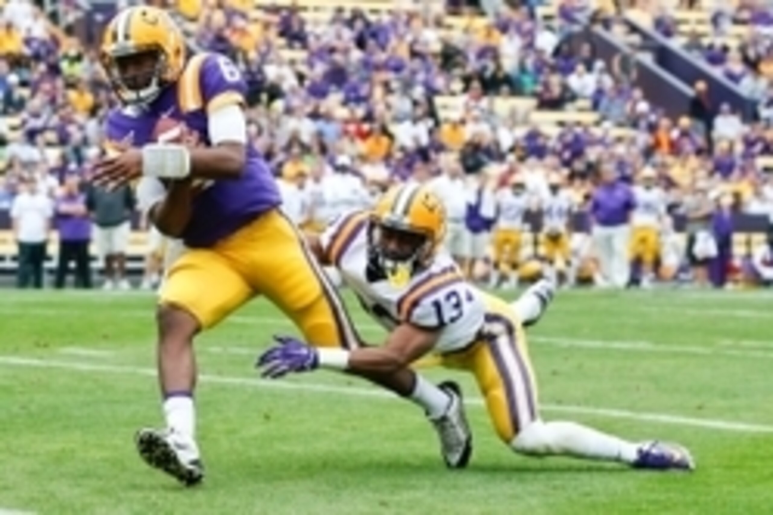 Apr 5, 2014; Baton Rouge, LA, USA; LSU Tigers quarterback Brandon Harris (6) runs for a touchdown past cornerback Dwayne Thomas (13) during the 2014 spring game at Tiger Stadium. Mandatory Credit: Derick E. Hingle-USA TODAY Sports