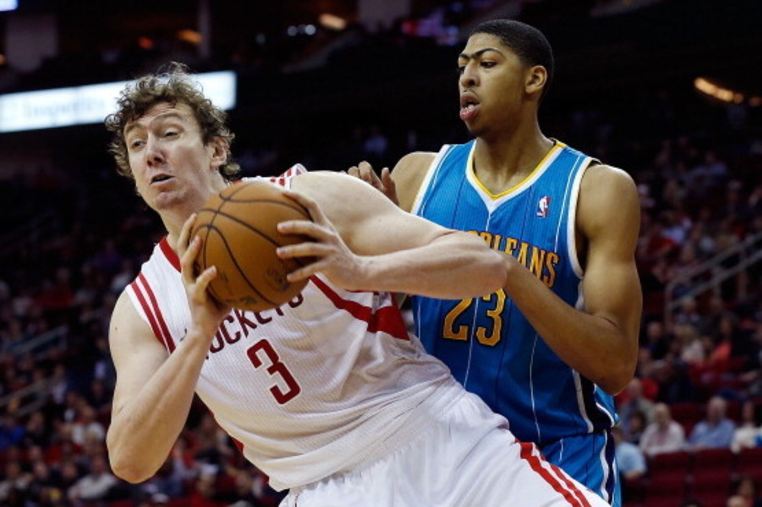 HOUSTON, TX - JANUARY 02:  Omer Asik #3 of the Houston Rockets grabs a rebound in front of Anthony Davis #23 of the New Orleans Hornets at Toyota Center on January 2, 2013 in Houston, Texas.  NOTE TO USER: User expressly acknowledges and agrees that, by d