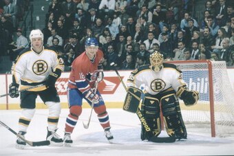 Canadiens forward Valeri Bure #18 waits for a pass while posted between Bruins defenceman Jon Rohloff #38 and goaltender Scott bailey #39 during   a game at the Molson Centre during the 1996-97 season.(Photo by Denis Brodeur/NHLI via Getty Images)