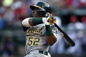 Jul 27, 2014; Arlington, TX, USA; Oakland Athletics left fielder Yoenis Cespedes (52) follows through for a two-run double against the Texas Rangers during the second inning of a baseball game at Globe Life Park in Arlington. Mandatory Credit: Jim Cowsert