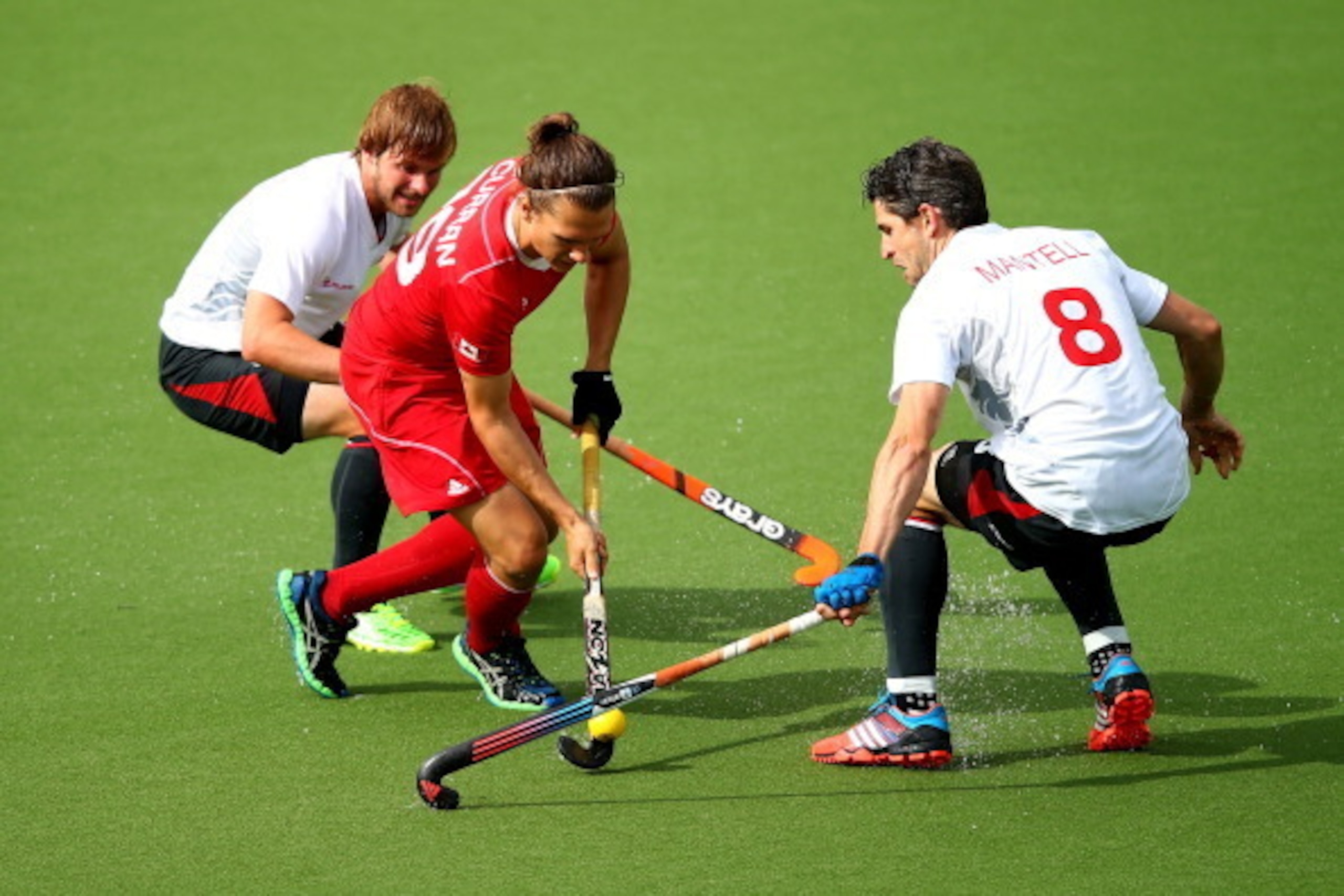 GLASGOW, SCOTLAND - JULY 31:  Taylor Curran of Canada is challenged by Simon Mantell of England during the men's Preliminaries Pool B match between England and Canada at the Glasgow National Hockey Centre during day eight of the Glasgow 2014 Commonwealth 