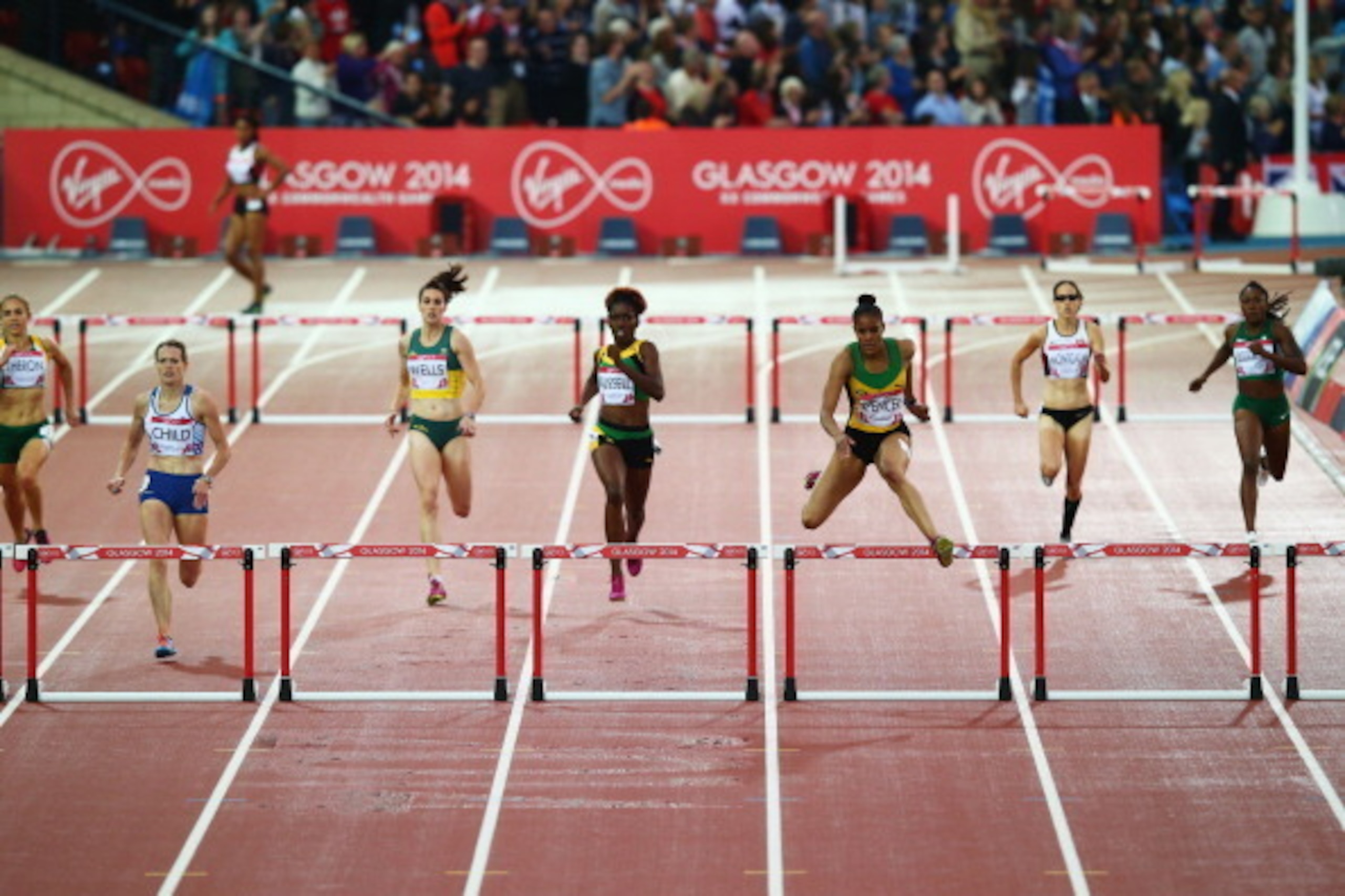 GLASGOW, SCOTLAND - JULY 31:  Kaliese Spencer of Jamaica (3R) clears the final hurdle ahead of Eilidh Child of Scotland (2L) in the Women's 400 metres hurdles final at Hampden Park during day eight of the Glasgow 2014 Commonwealth Games on July 31, 2014 i