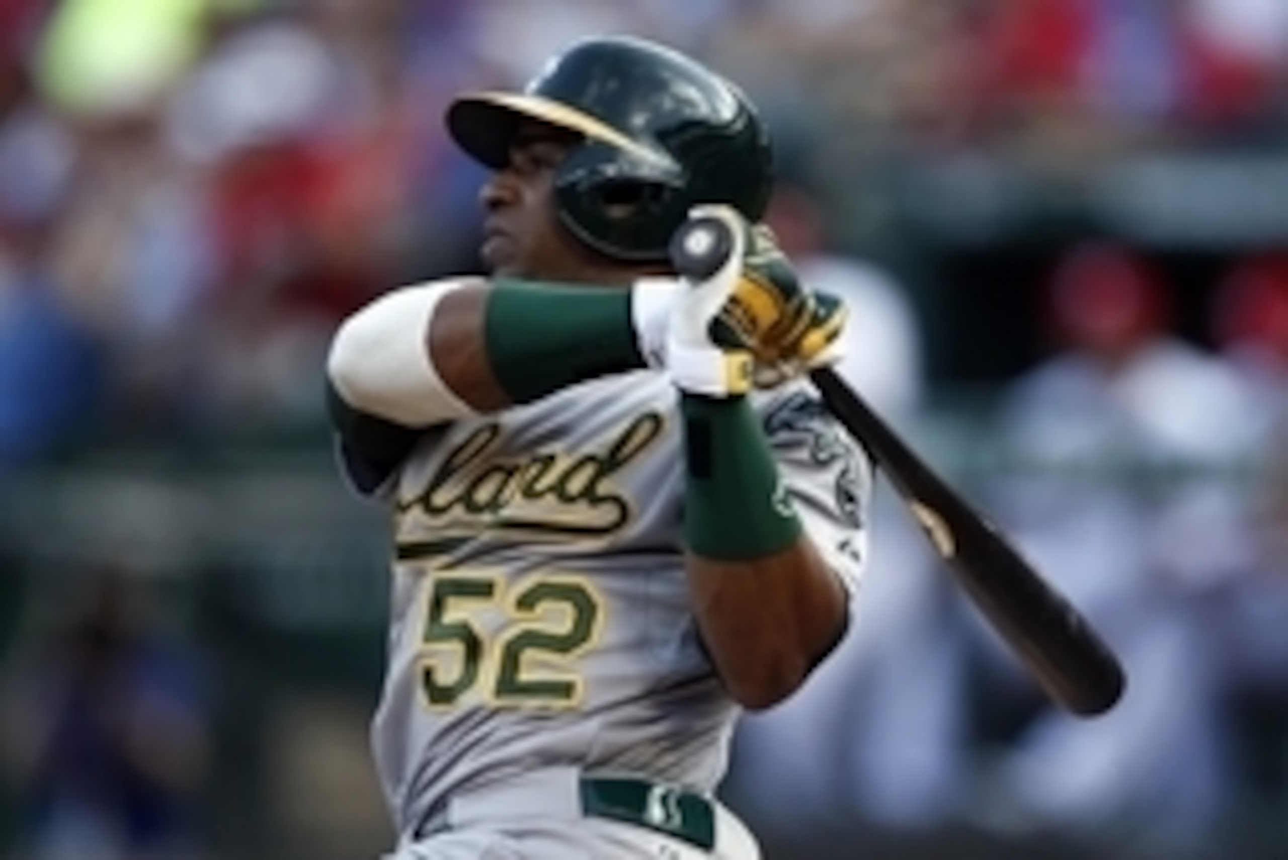 Jul 27, 2014; Arlington, TX, USA; Oakland Athletics left fielder Yoenis Cespedes (52) follows through for a two-run double against the Texas Rangers during the second inning of a baseball game at Globe Life Park in Arlington. Mandatory Credit: Jim Cowsert
