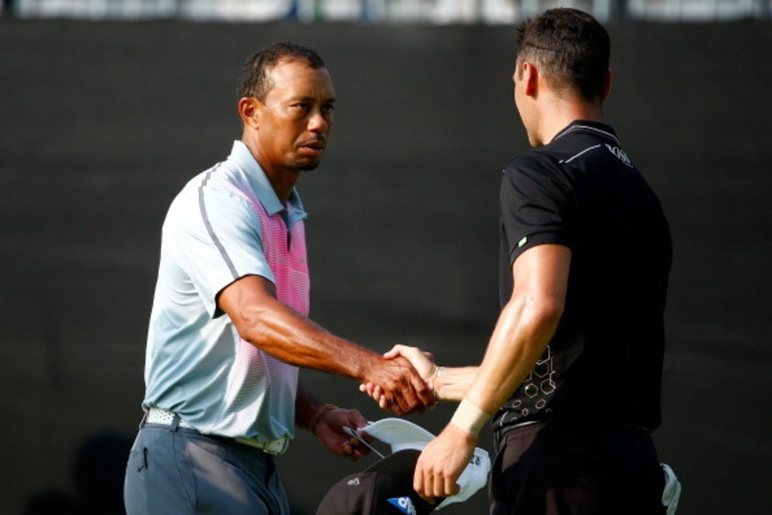 AKRON, OH - JULY 31:  Tiger Woods (L) and Martin Kaymer of Germany shake hands on the 18th green during the first round of the World Golf Championships-Bridgestone Invitational at Firestone Country Club South Course on July 31, 2014 in Akron, Ohio.  (Phot