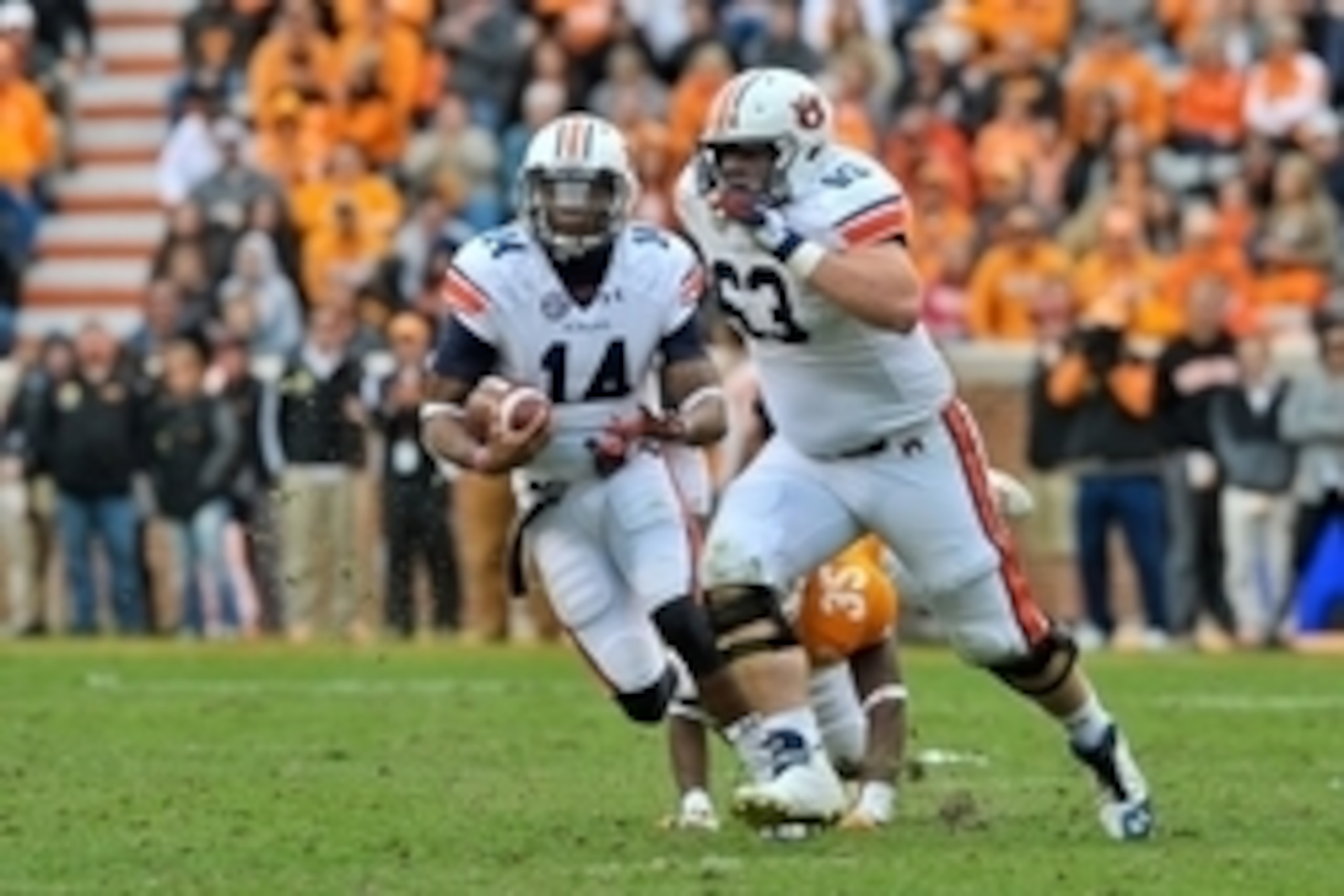 Nov 9, 2013; Knoxville, TN, USA; Auburn Tigers offensive linesman Alex Kozan (63) gets set to block for Auburn quarterback Nick Marshall (14) as he rushes away from Tennessee Volunteers defensive back JaRon Toney (35) during the second half at Neyland Sta