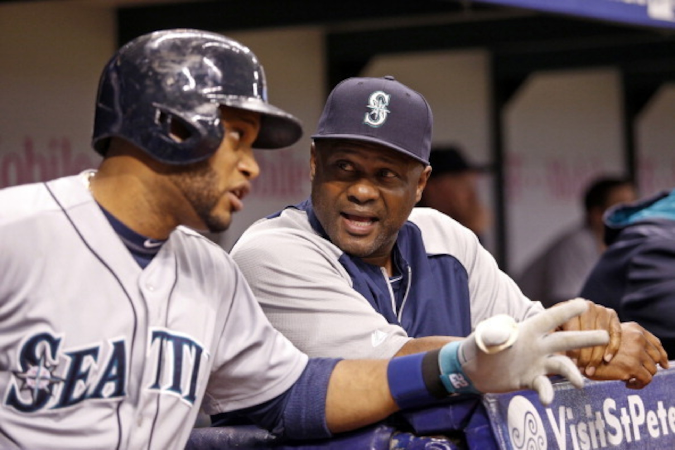 ST. PETERSBURG, FL - JUNE 6:  Manager Lloyd McClendon #23 of the Seattle Mariners speaks with Robinson Cano #22 of the Seattle Mariners in the dugout during the third inning of a game against the Tampa Bay Rays on June 6, 2014 at Tropicana Field in St. Pe